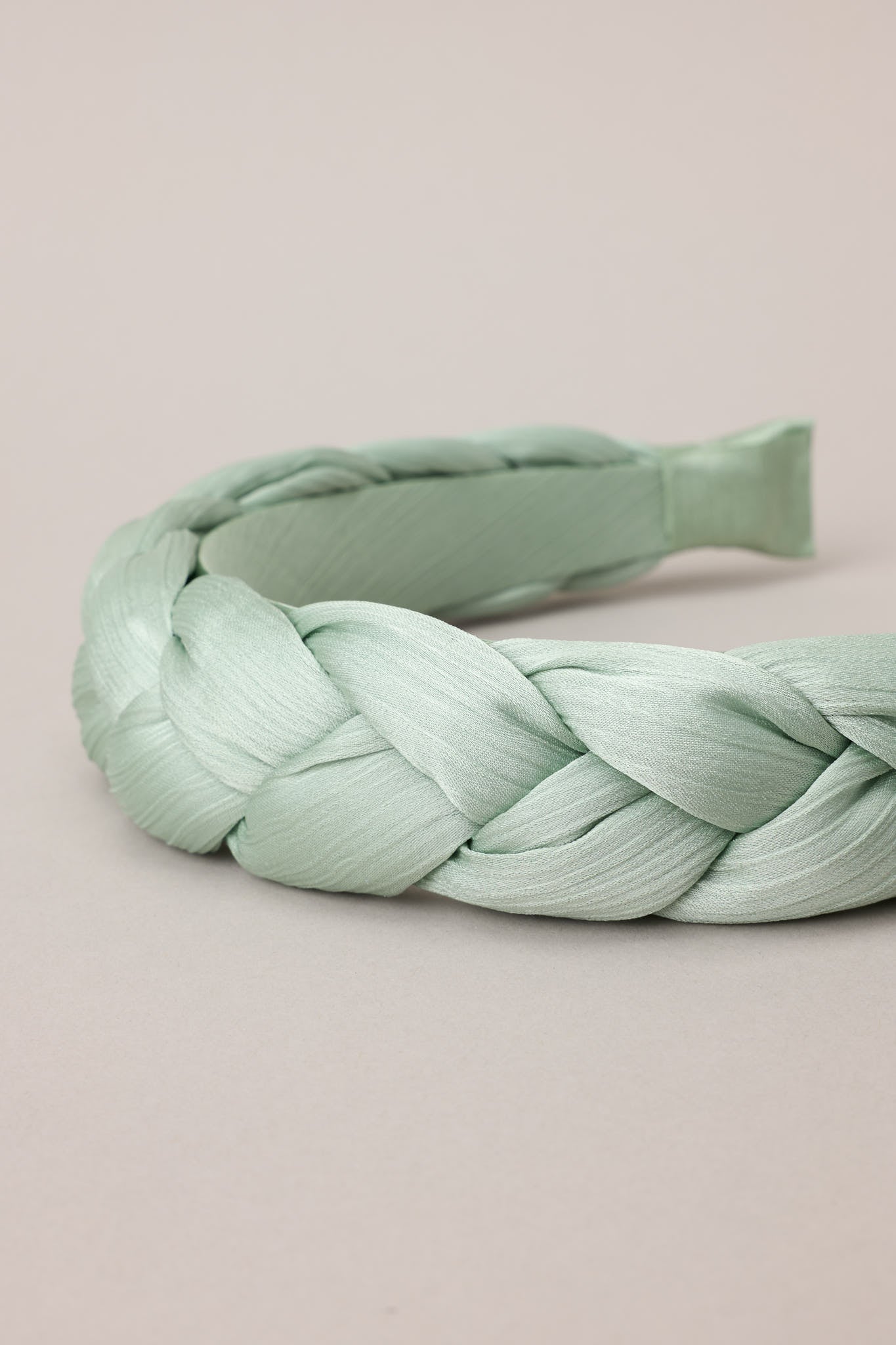 Close up view of this headband featuring a thick, soft material, and a braided texture.