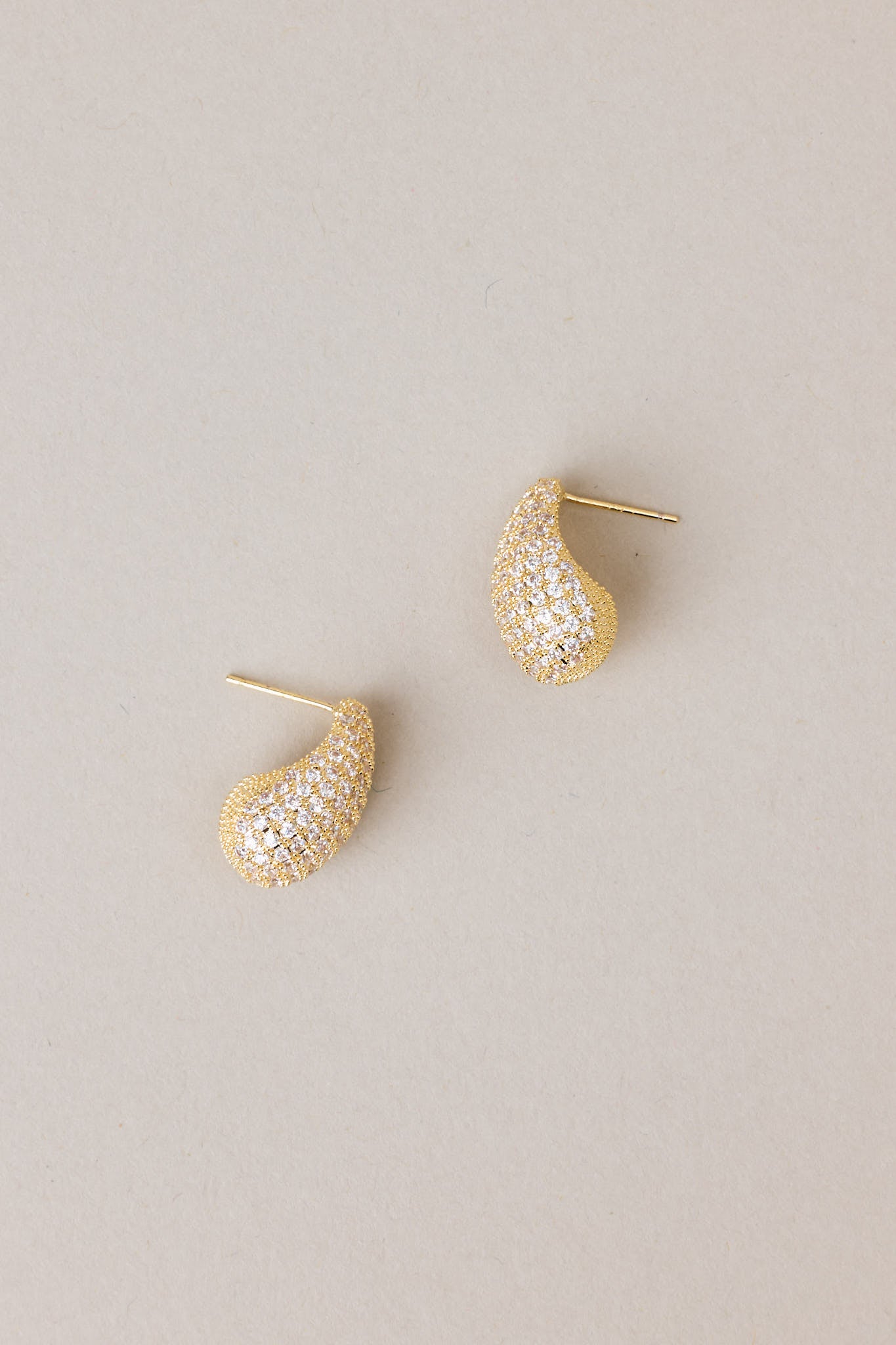 Tear shaped yellow gold earring with mini rhinestones covering it, and gold hardware. 