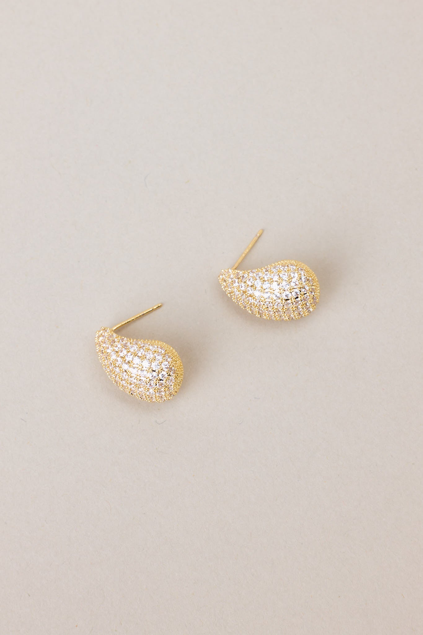 Full view of these tear shaped yellow gold earring with mini rhinestones covering it, and gold hardware.