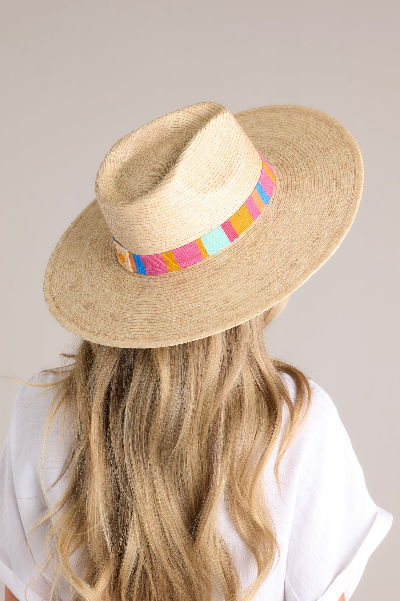 Back view of this hat that features a multicolor cotton woven band, and is handmade with palm fronds.