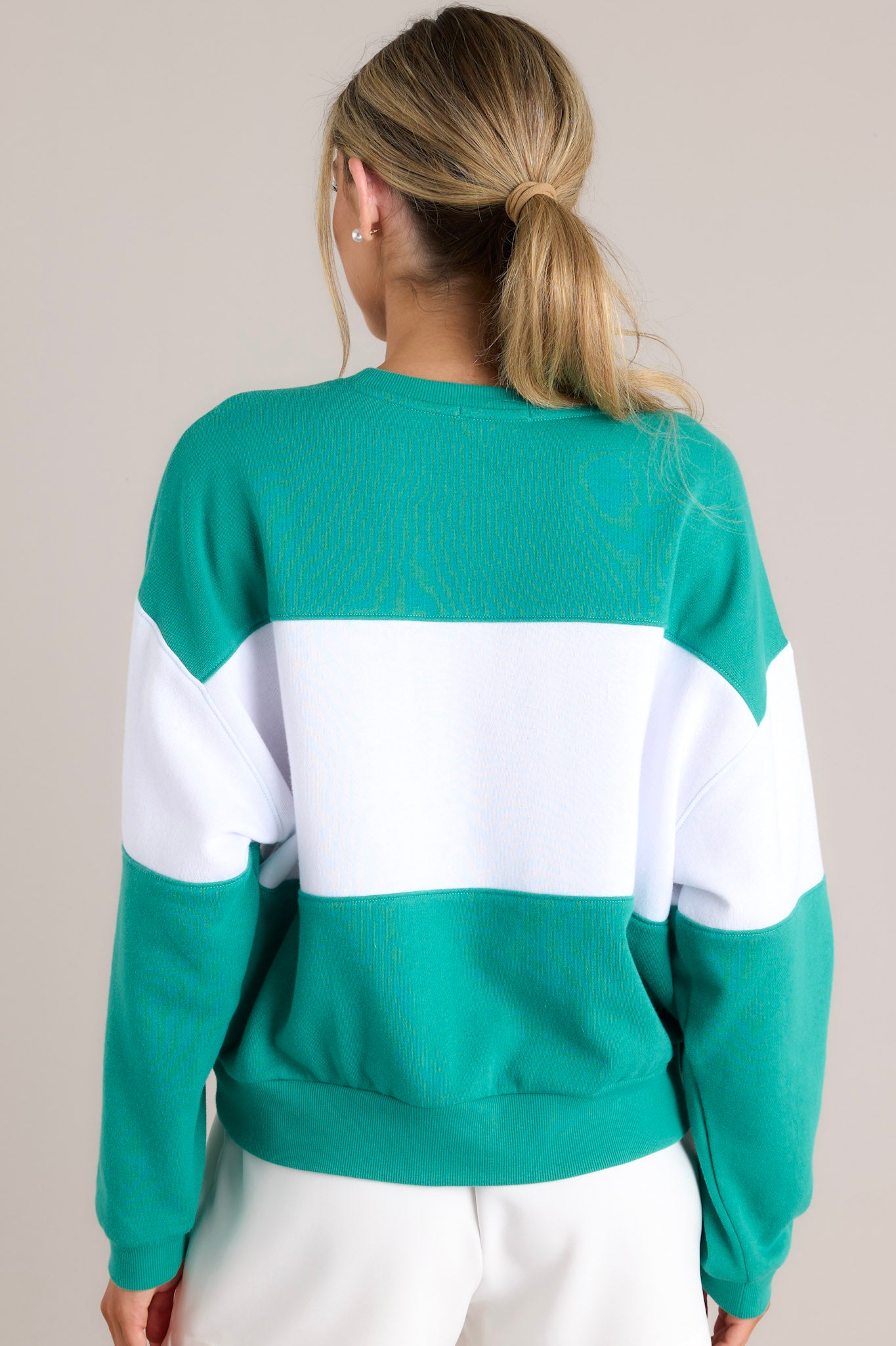 Back view of this sweatshirt that features a ribbed crew neckline, high contrast color blocking, embroidered & terry cloth wording, ribbed cuffed sleeves, and a ribbed hemline.