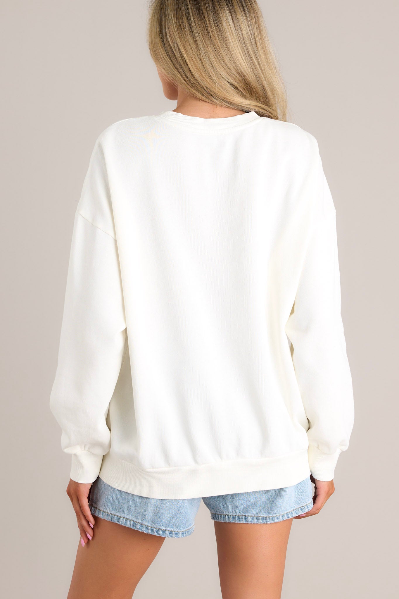 Back view of this sweatshirt that features a crew neckline, a unique graphic, ribbed cuffed long sleeves, and a ribbed hemline.