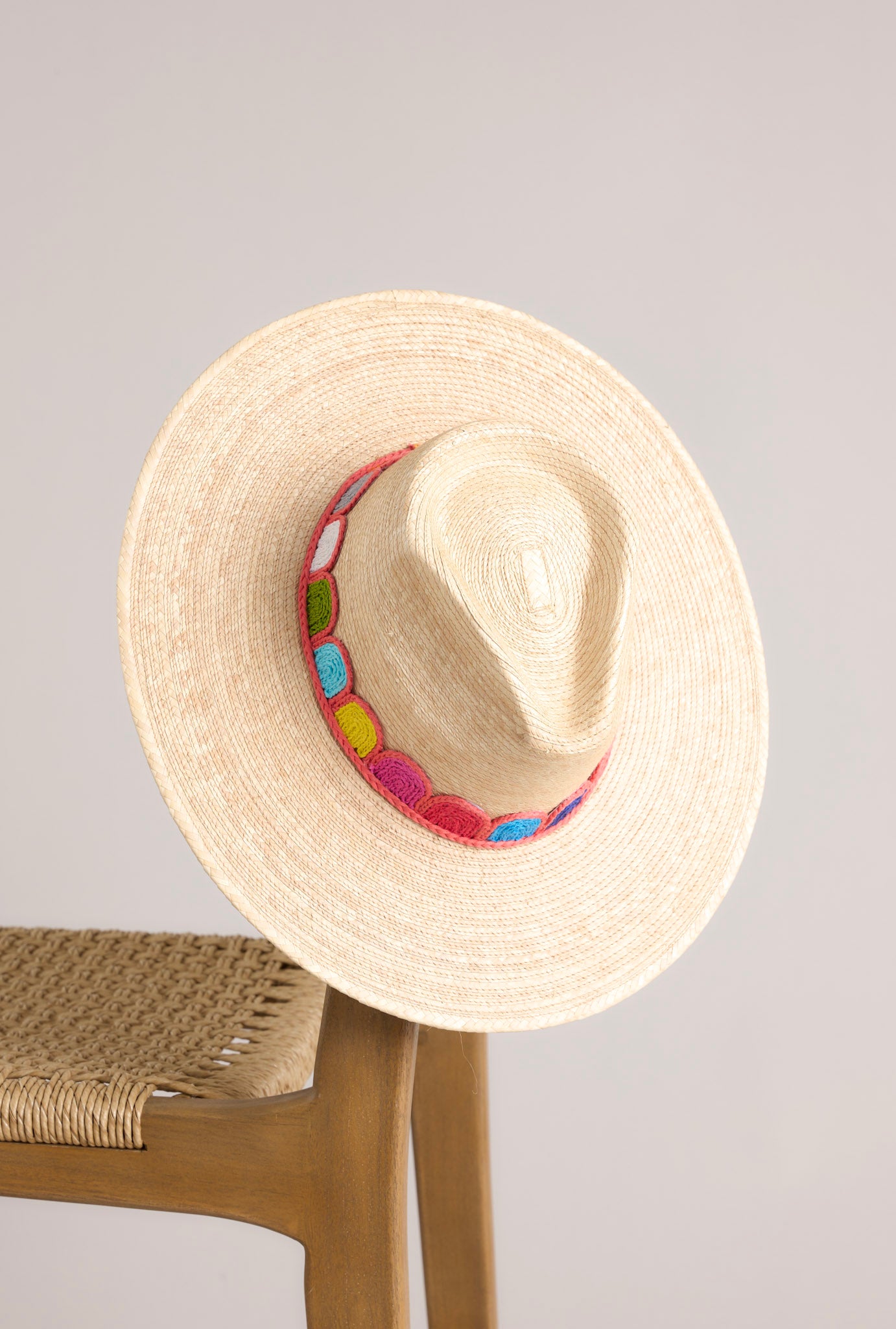 Top view of this hat that features a woven striped band, and is handmade with palm fronds.