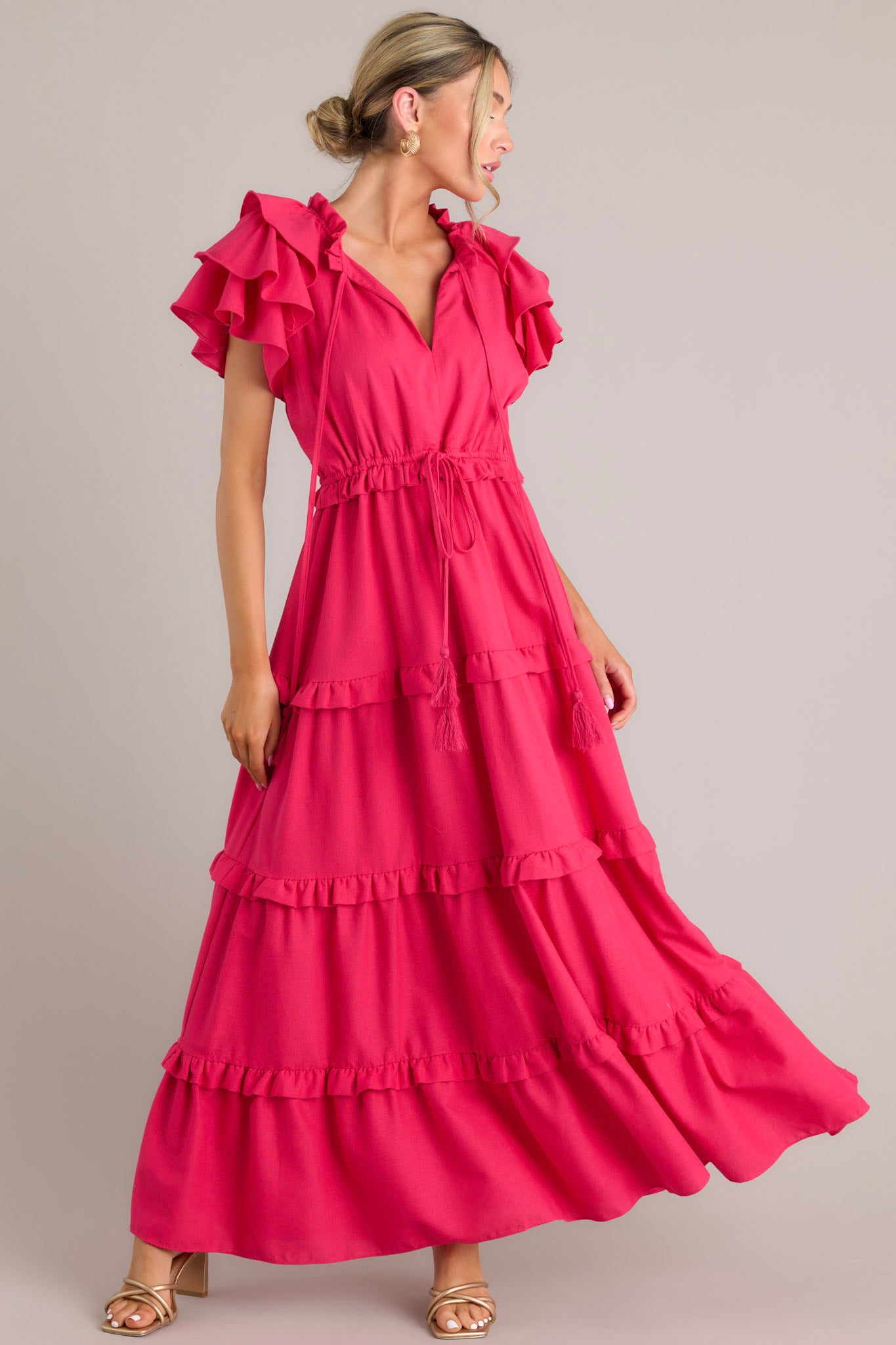 Full body view of this dress that features a v-neckline with a self-tie closure, ruffled flutter sleeves, a drawstring waistband, and a long, flowy skirt.