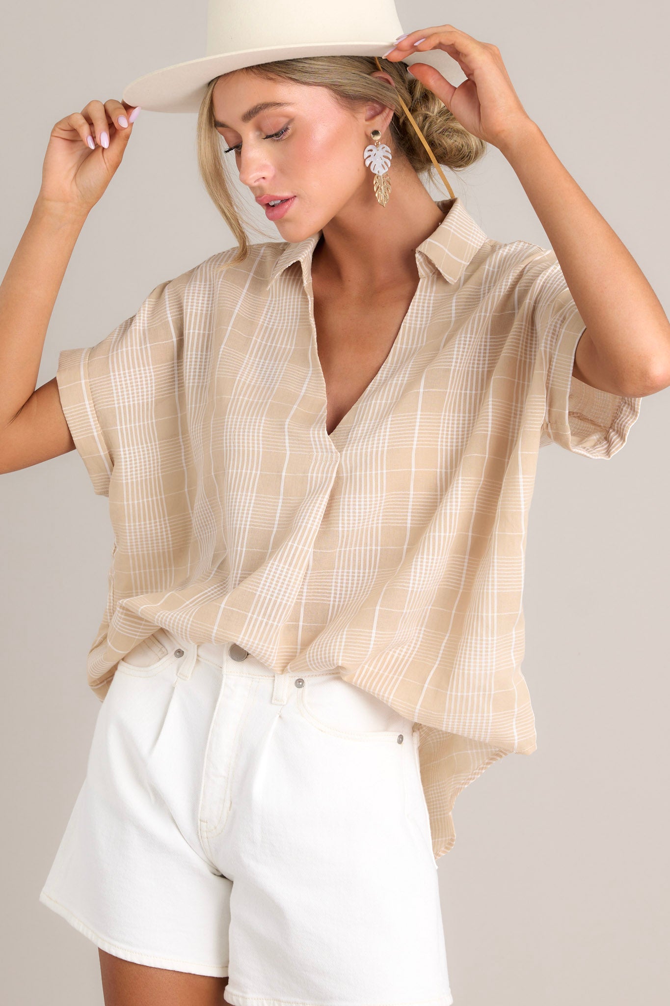 Front view of this top that features a collared v-neckline, a lightweight material, functional buttons down the back, and cuffed short sleeves.