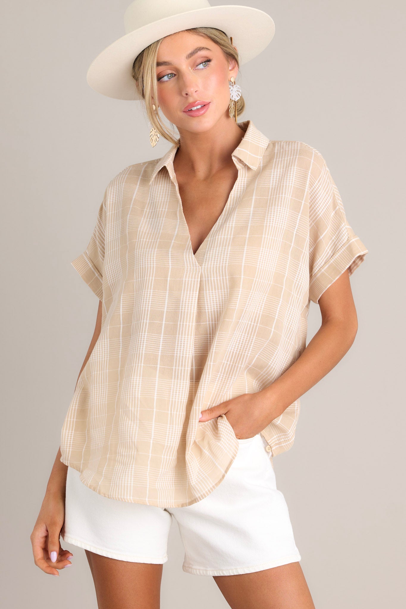 Full front view of this top that features a collared v-neckline, a lightweight material, functional buttons down the back, and cuffed short sleeves.