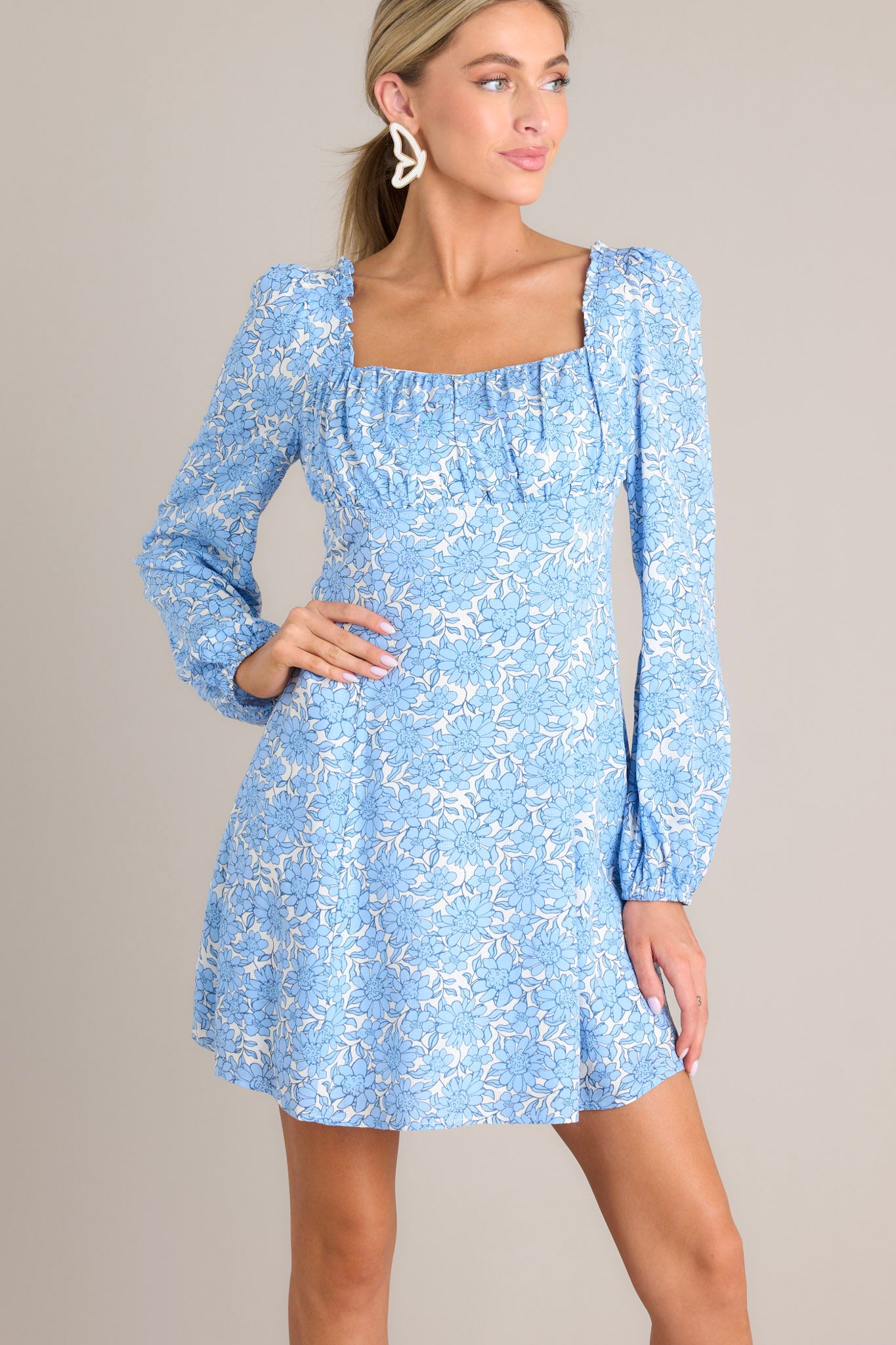 Front view of this dress that features a square neckline, ruching in the bust, a smocked back insert, a discrete side zipper, and elastic cuffed long sleeves.