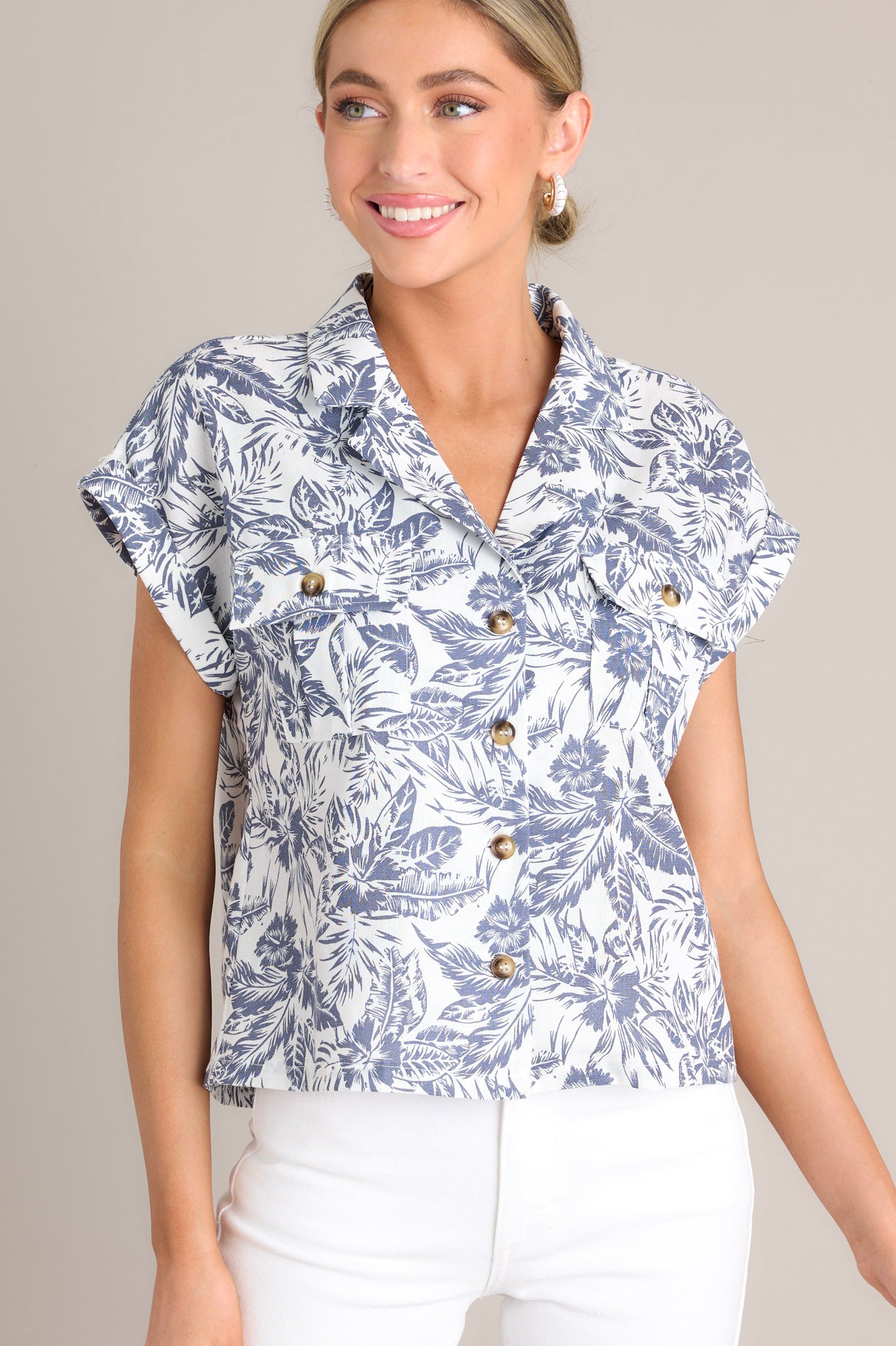 Front view of this top that features a collared v-neckline, functional button front design, breast pockets, and dolman sleeves.