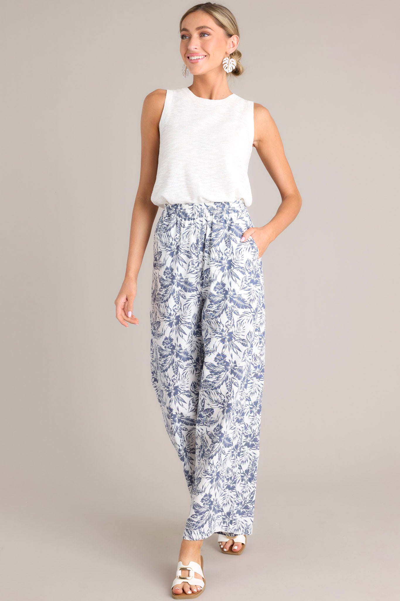 Full body view of these pants that feature a high waisted design, an elastic waistband, functional hip pockets, a unique pattern, and a wide leg design.