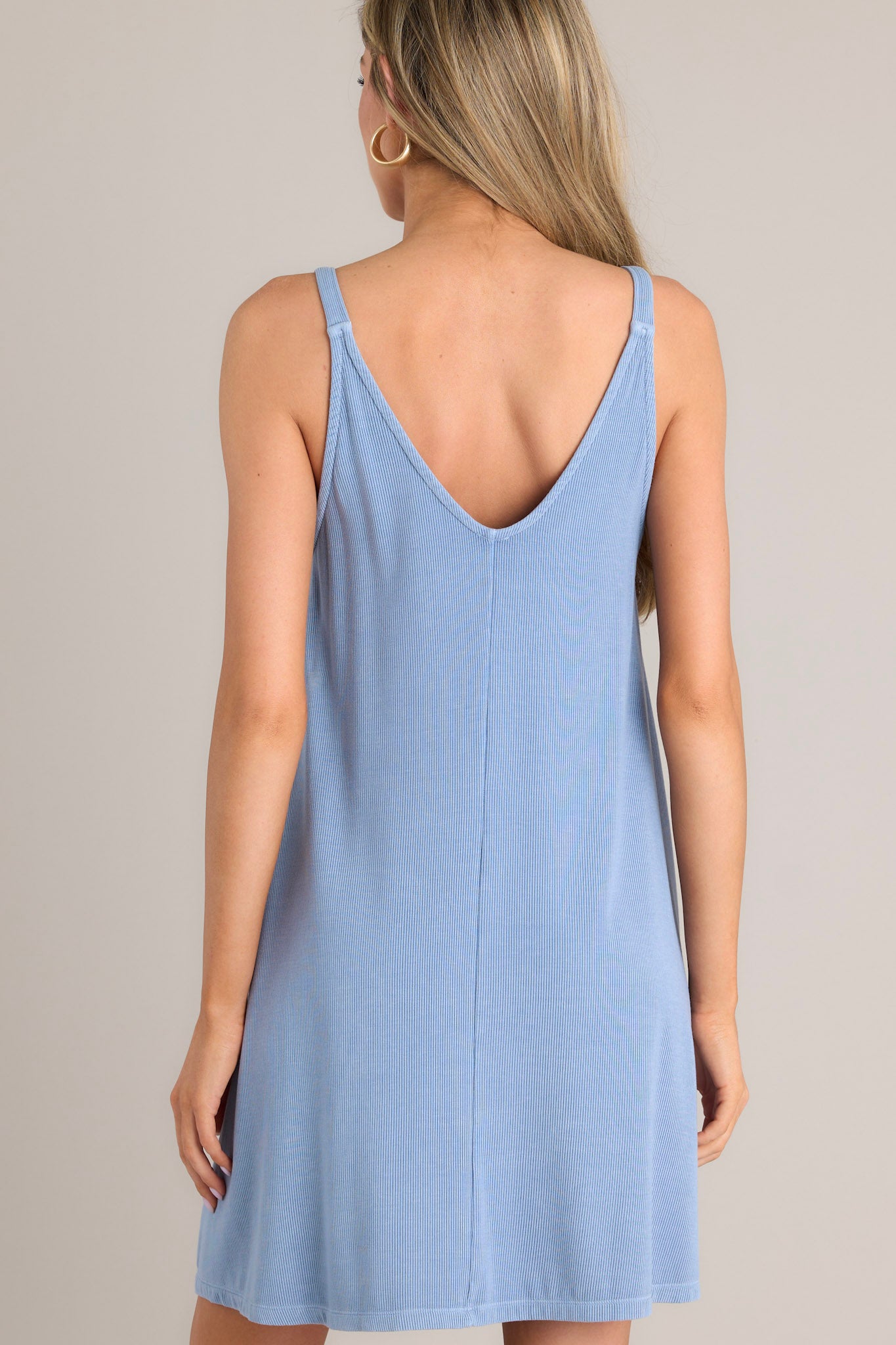 Back view of this blue ribbed dress that features a v-neckline, a seam down the front and back and, a soft & lightweight material.