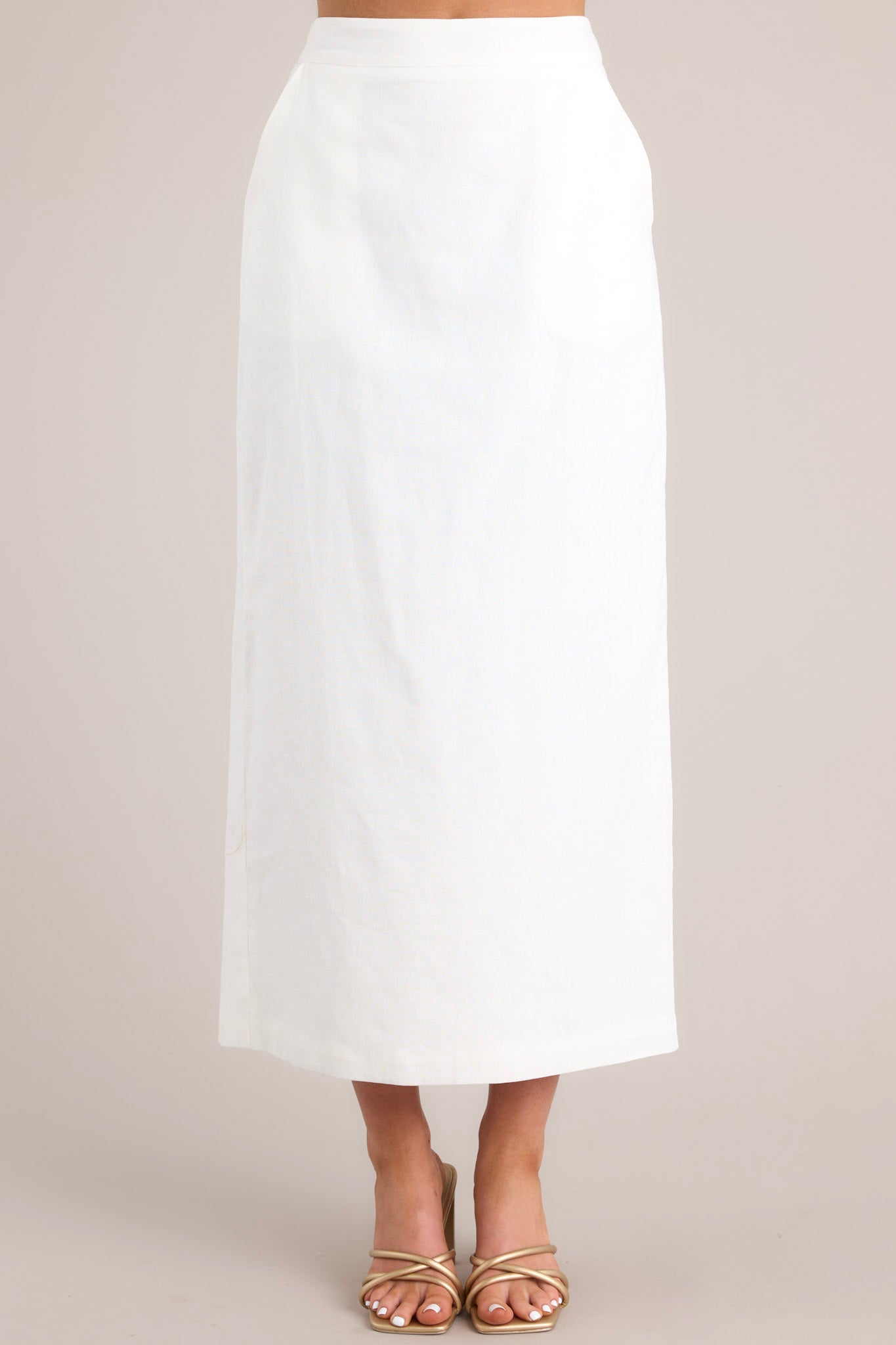 Front view of this skirt that features a high waisted design, a functional zipper in the back of the waist, functional hip pockets, and a slit in the back.