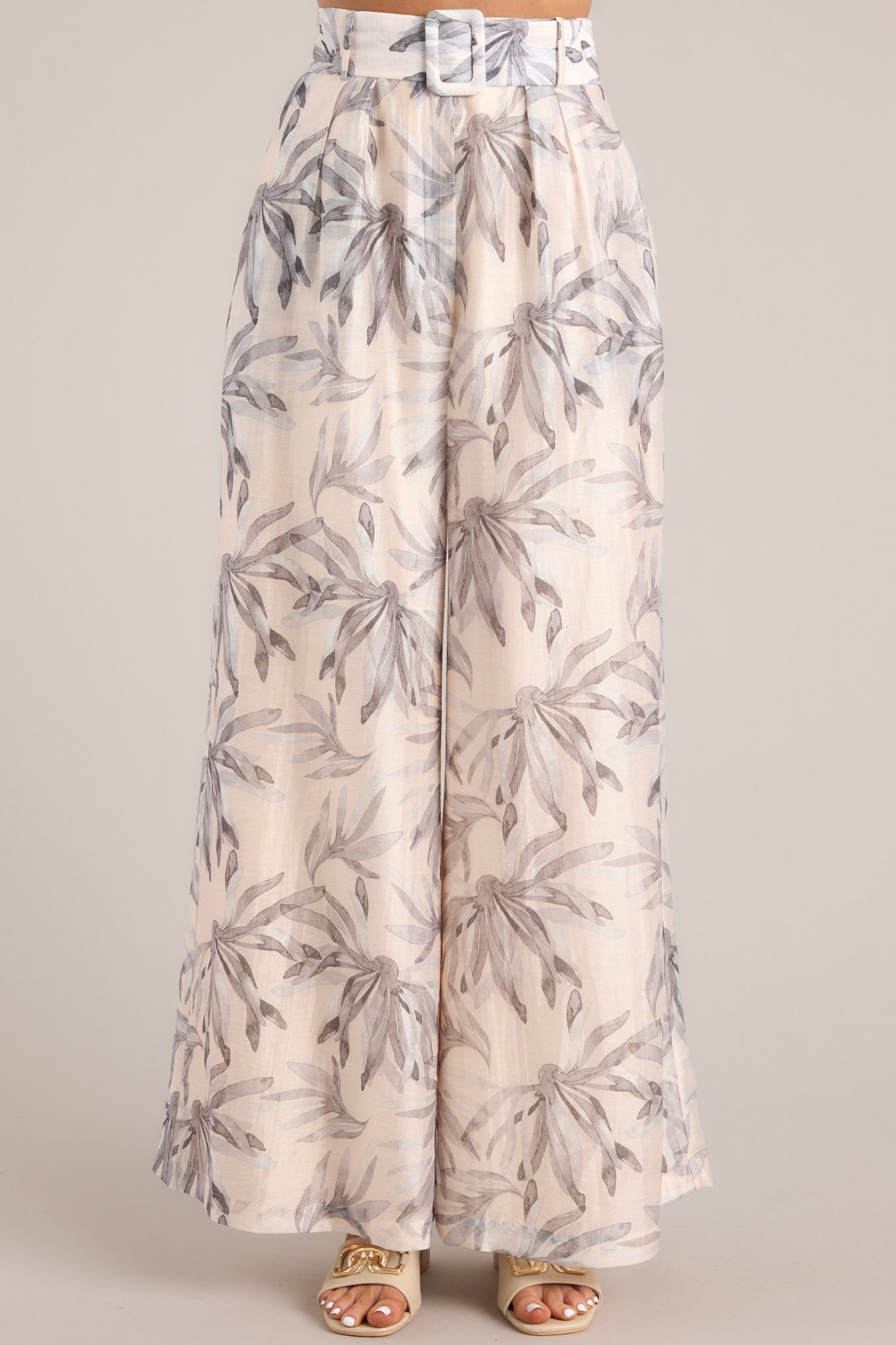 Front view of these pants that feature the tropical leaf pattern of the fabric.