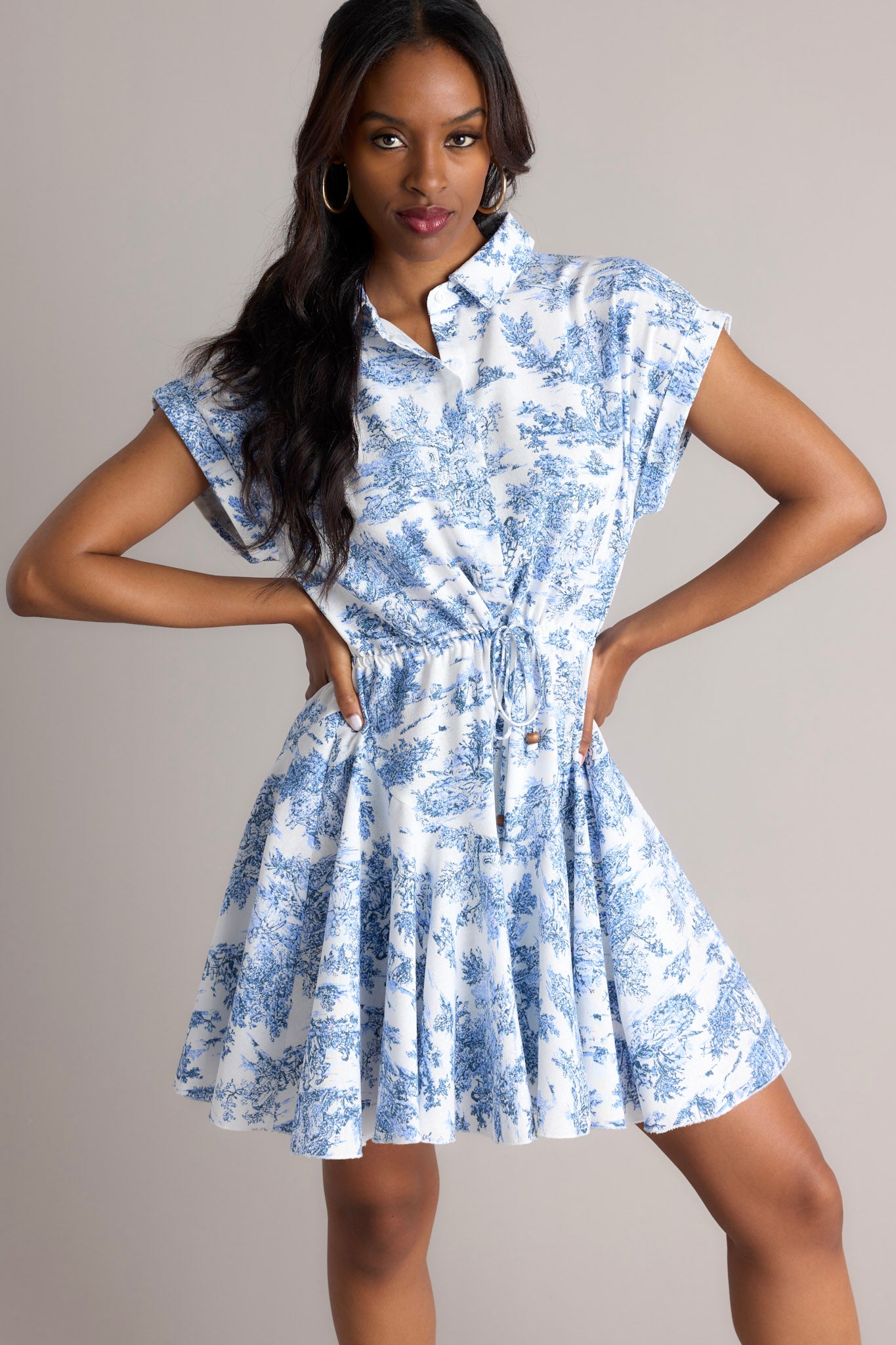 Front view of this dress that features a collared neckline, functional buttons, a self-tie waist feature, a flowy skirt, and wide cuffed short sleeves.