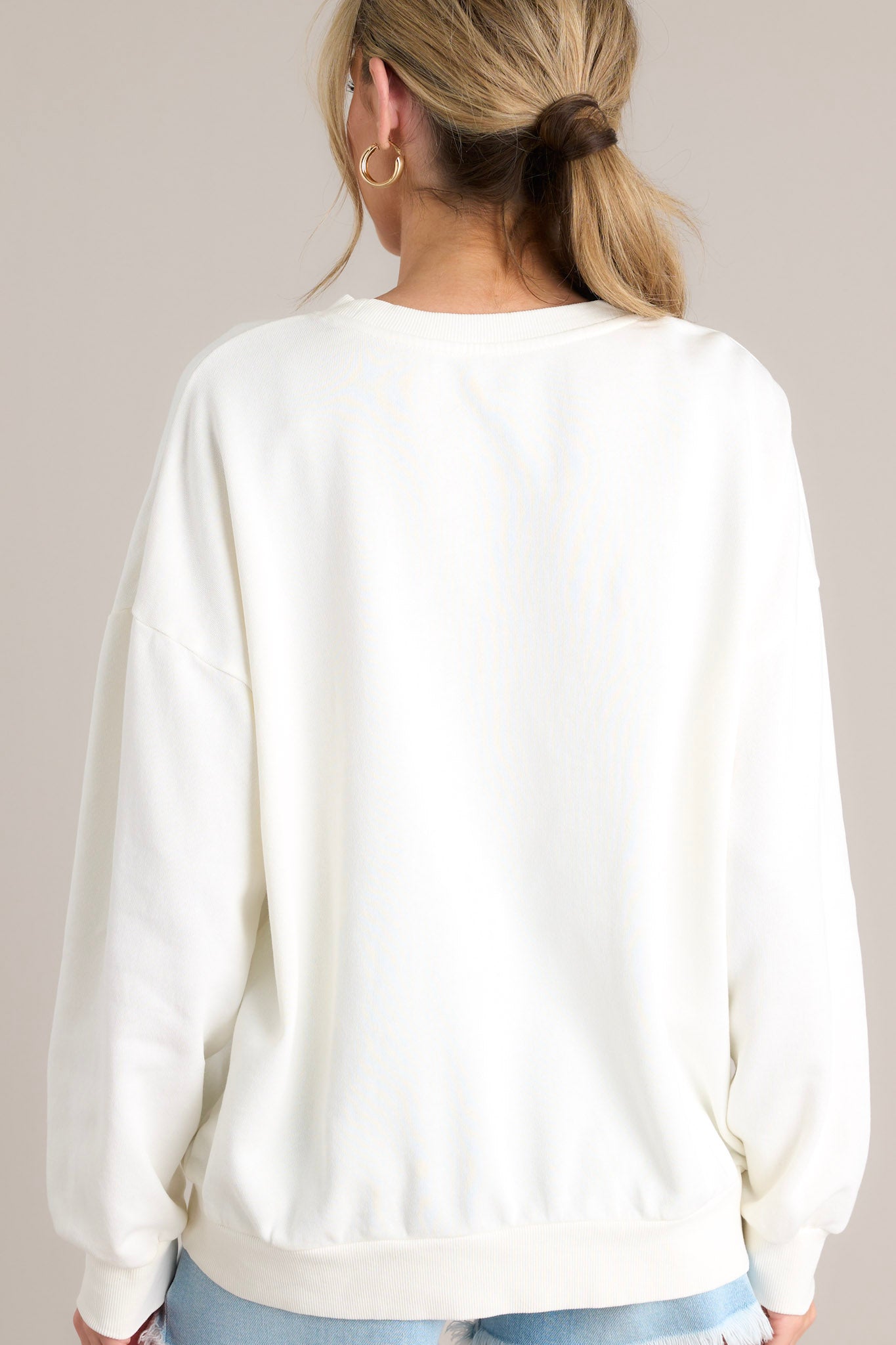 Back view of that features a crew neckline, a summer themed graphic, ribbed cuffed long sleeves, and a ribbed hemline.