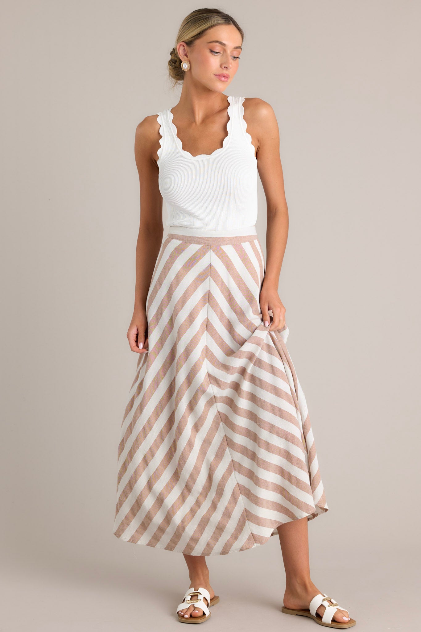 Full front view of this skirt that features a high waisted design, a functional zipper and hook closure in the back, a diagonal striped pattern, and a flowy fabric.