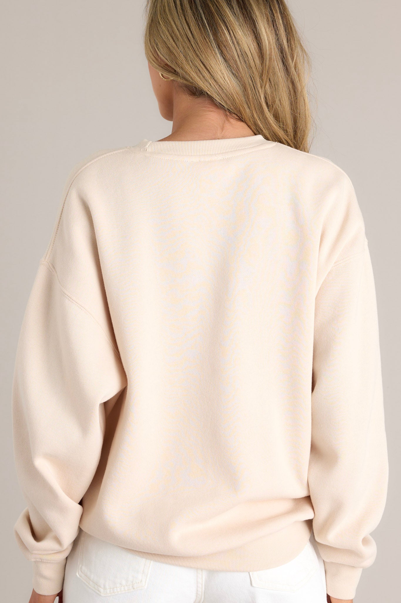 Back view of this Beige embroidered sweatshirt featuring "California" across the bust, crew neckline, and ribbed hems.