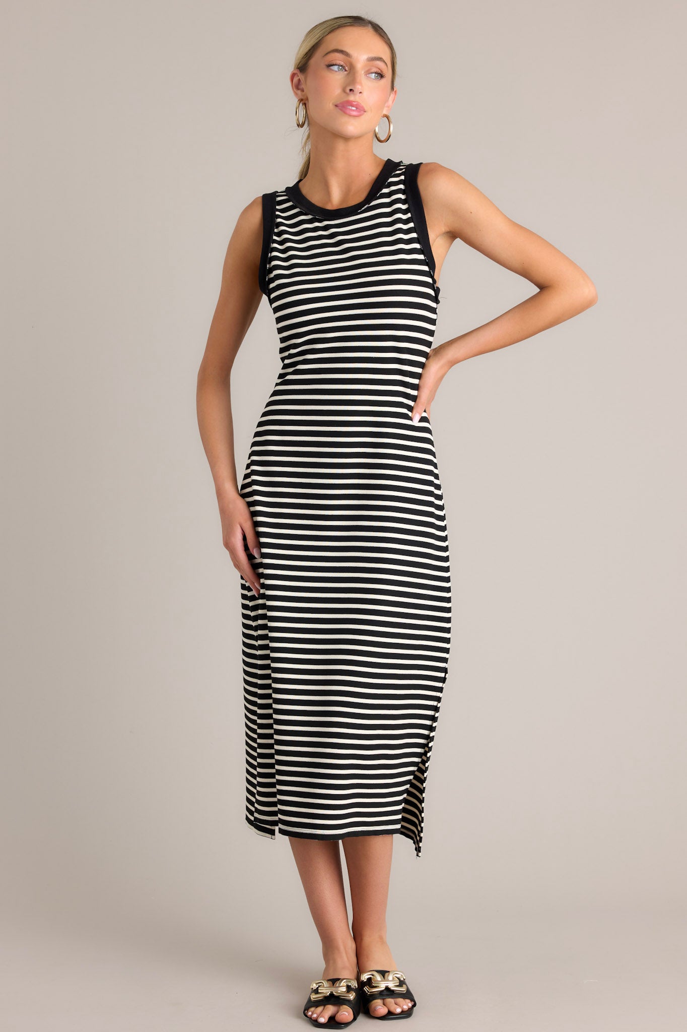 This black stripe midi dress features a crew neckline, a classic horizontal stripe design, and a split hemline.