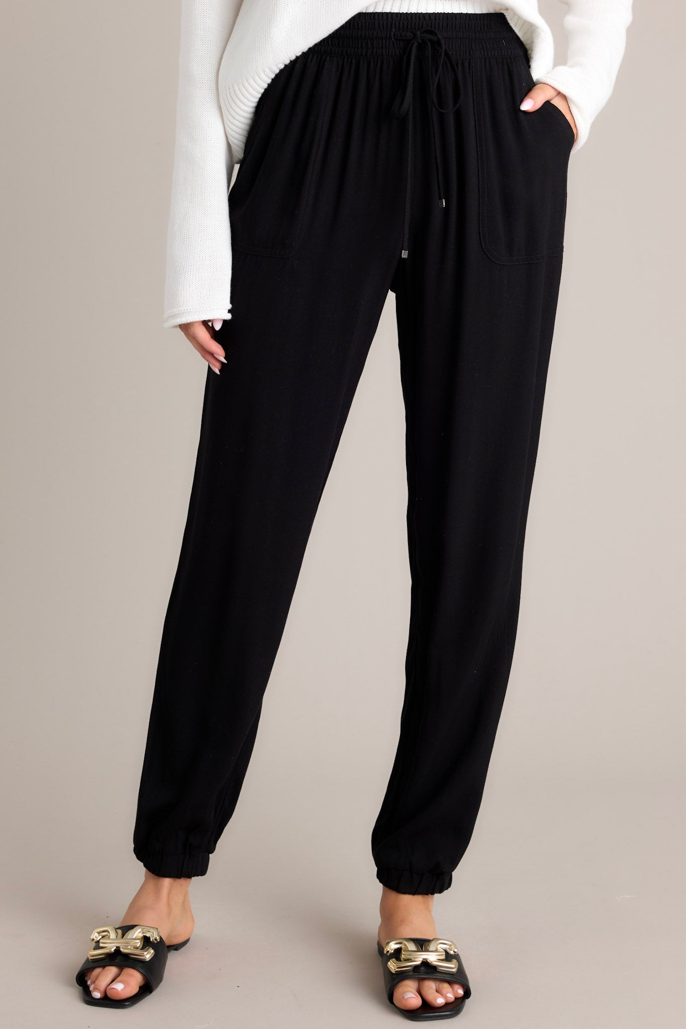 Front view of these joggers that feature an elastic waist with a self-tie drawstring, two functional waist pockets, an elastic ankle, and a lightweight breathable fabric.