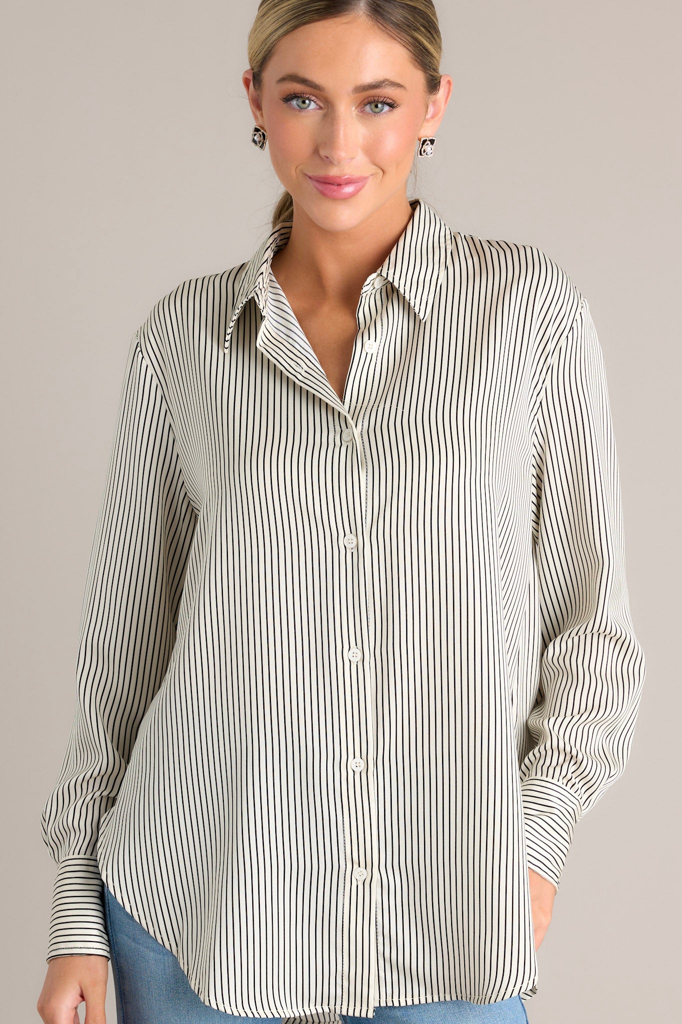 Front view of this fully untucked white & black top that features a collared neckline, buttons down the front, buttons at the cuff, and a classic relaxed fit.