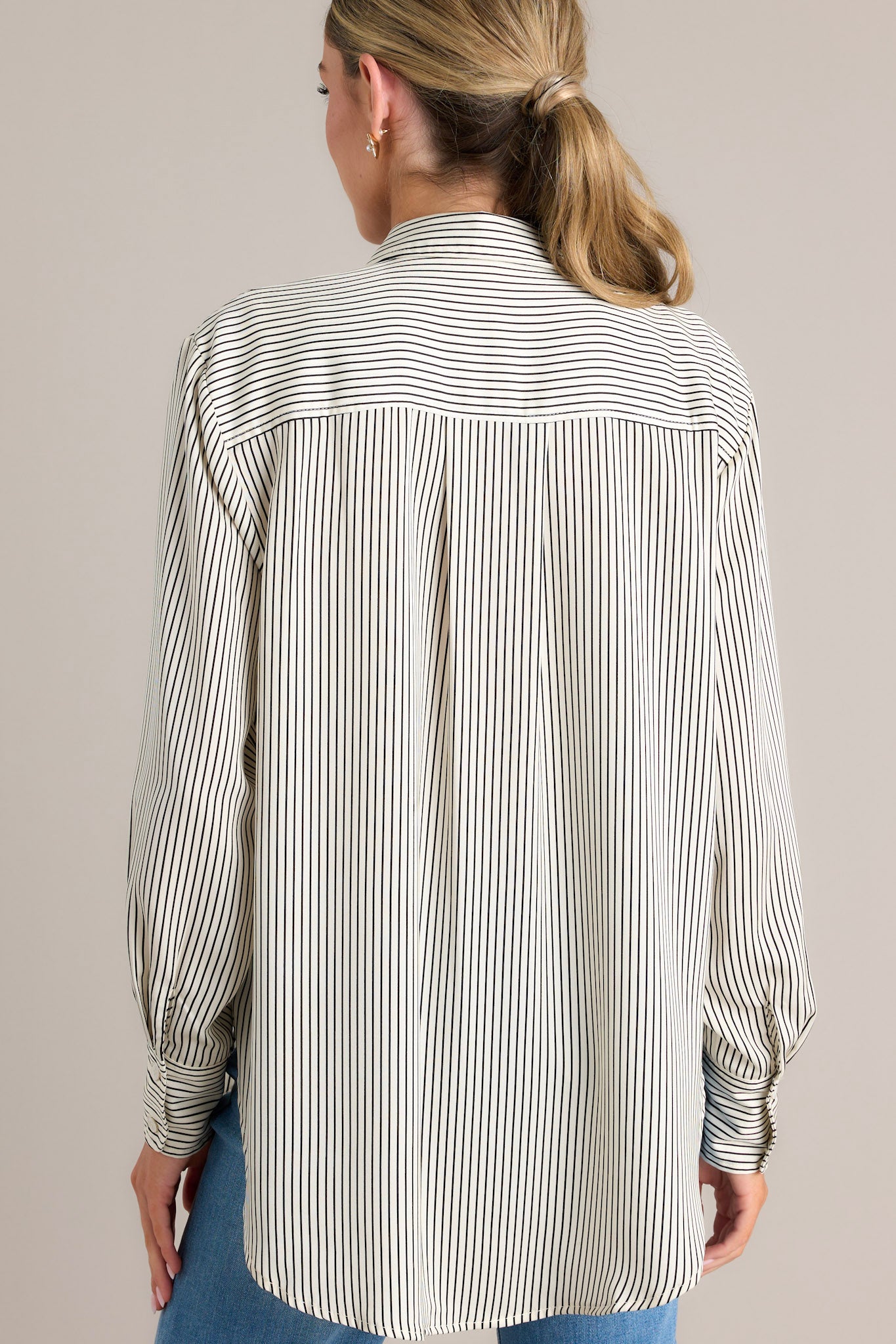 Back view of this white & black top that features a collared neckline, buttons down the front, buttons at the cuff, and a classic relaxed fit.