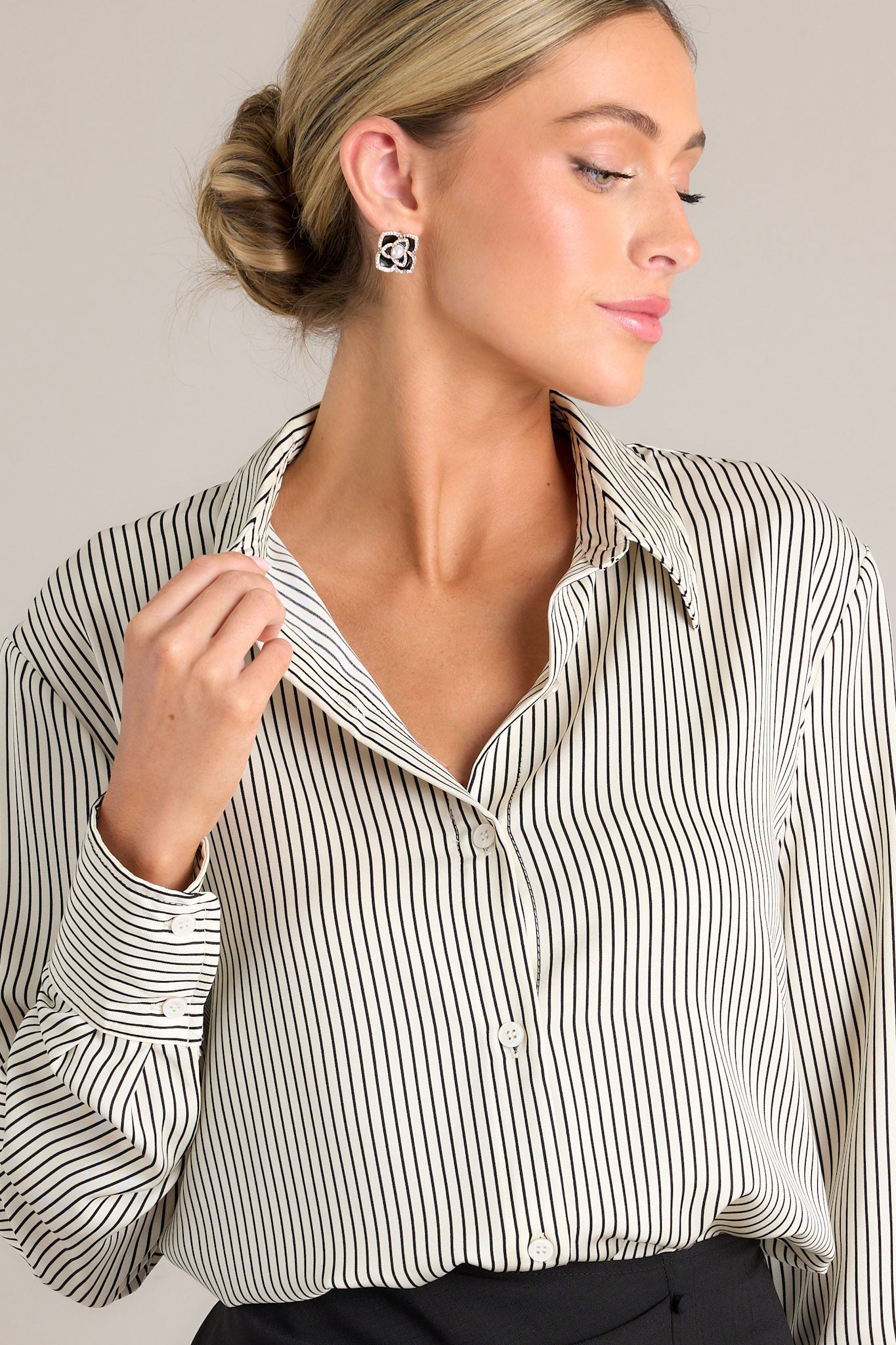 Front view of this fully tucked in white & black top that features a collared neckline, buttons down the front, buttons at the cuff, and a classic relaxed fit.