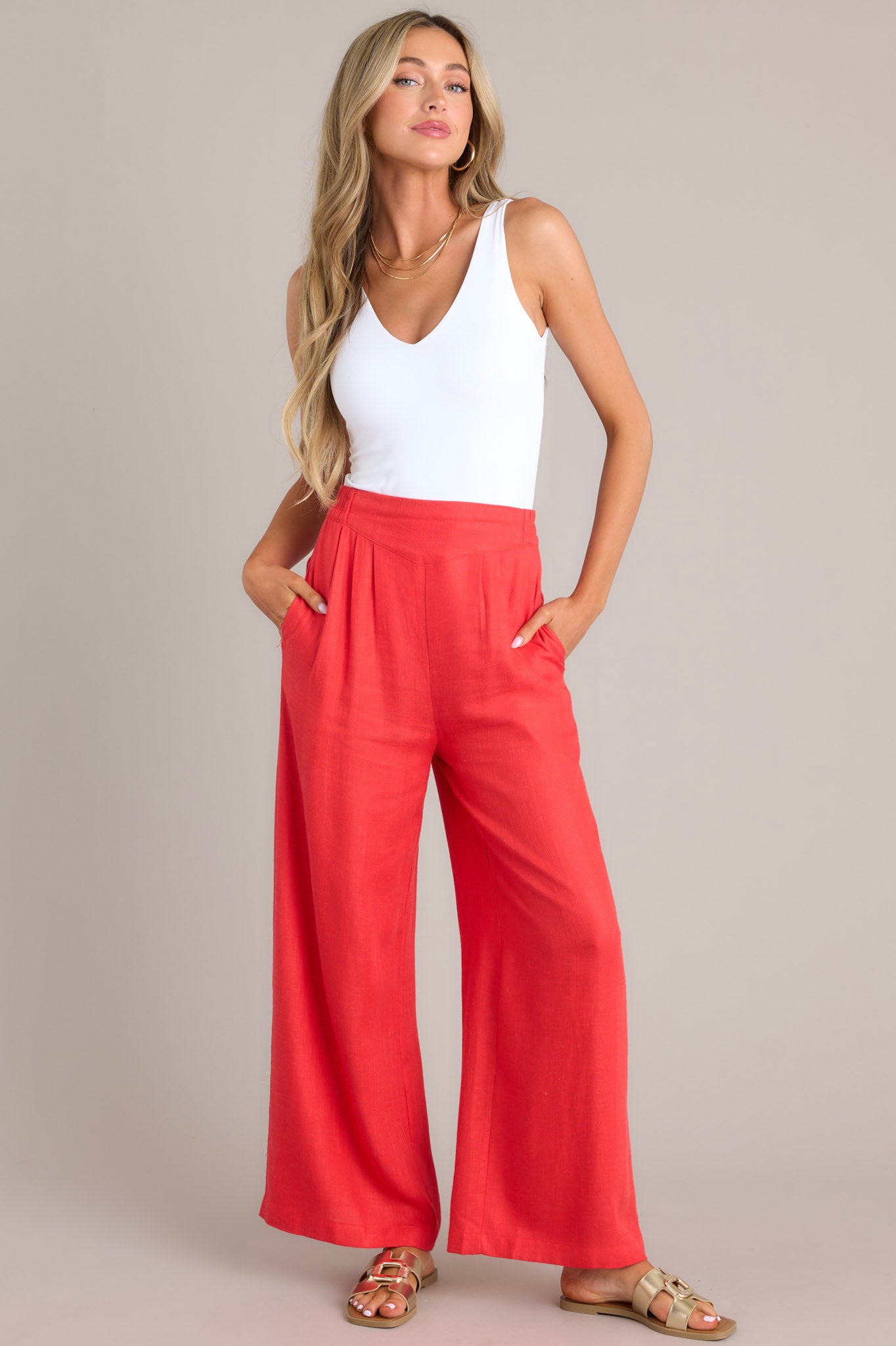 Front view of these pants that feature a high waisted design, an elastic insert in the back, functional hip pockets, a lightweight fabric, and a wide leg design.