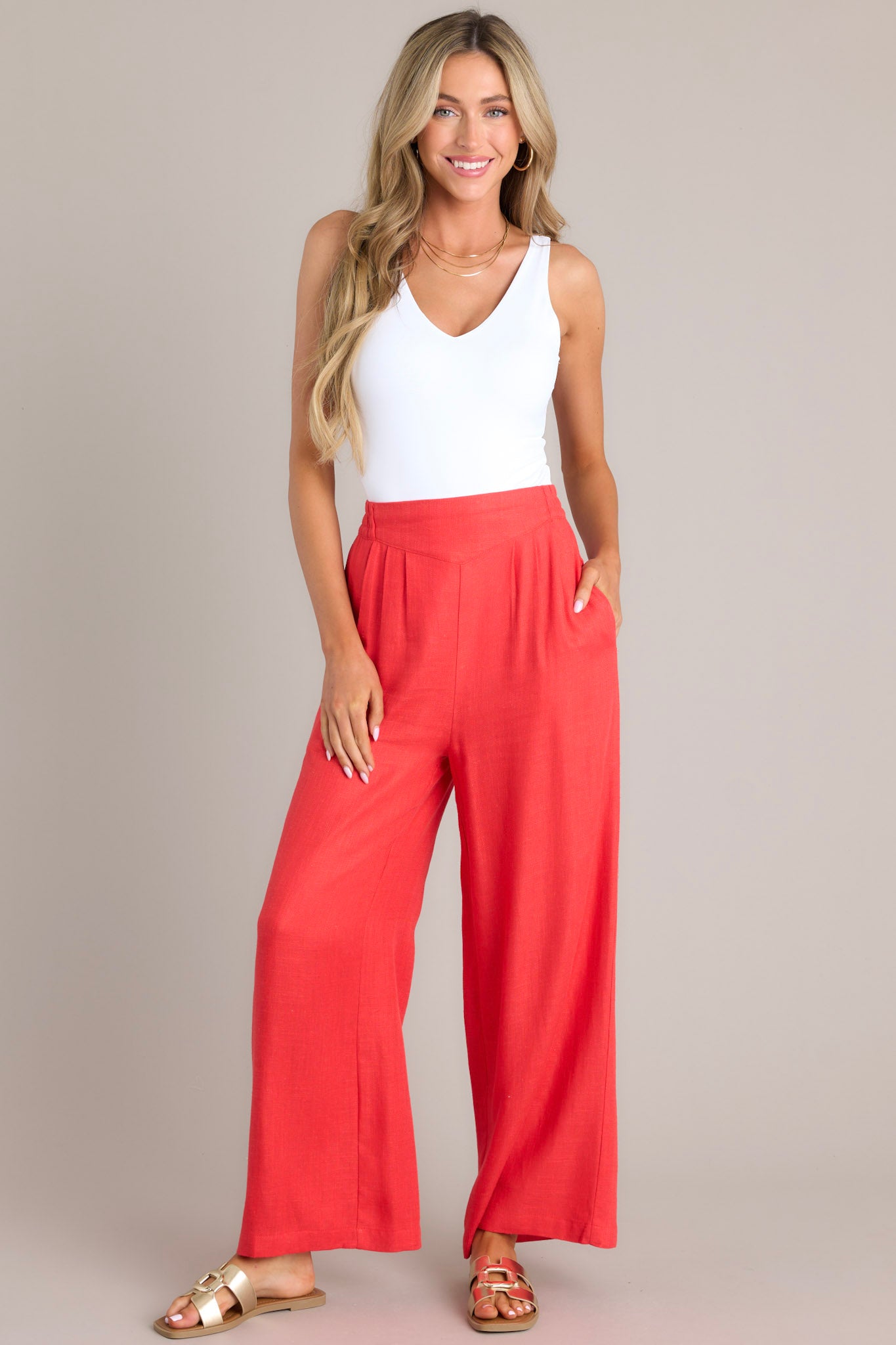 A full body view of these pants that feature a high waisted design, an elastic insert in the back, functional hip pockets, a lightweight fabric, and a wide leg design.