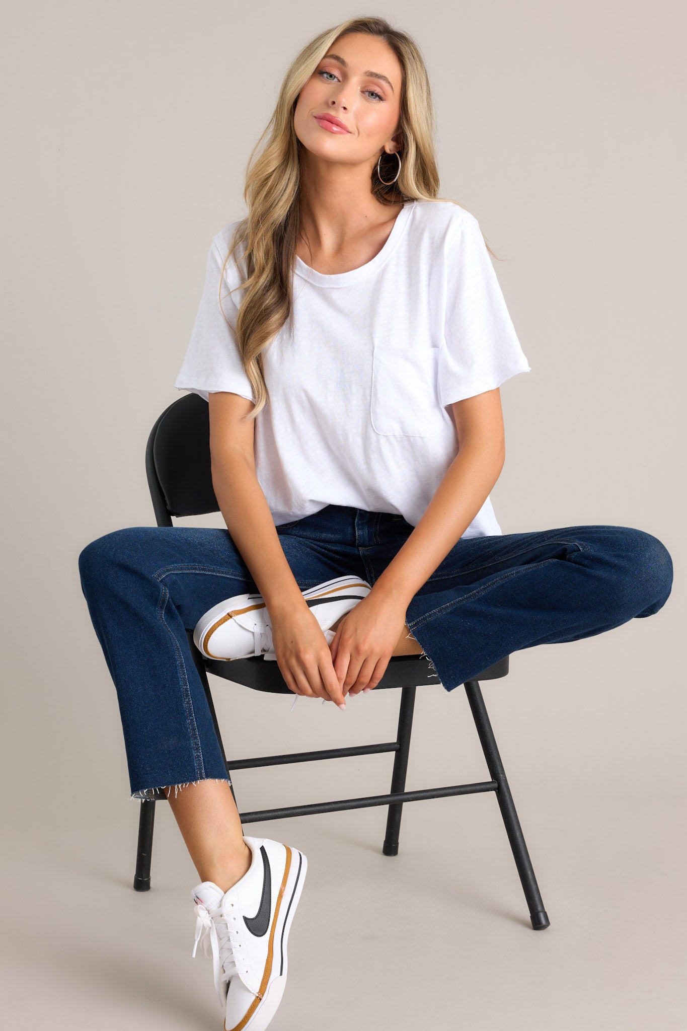 This white tee features a crew neckline, a functional breast pocket, a raw hemline, and short sleeves.