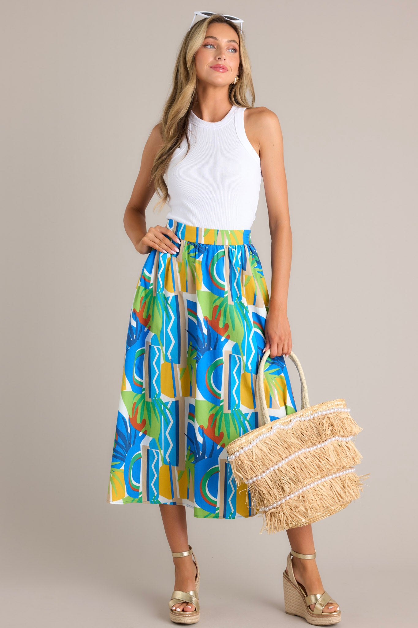 Full body view of a vibrant, high-waisted A-line skirt with an abstract blue, green, and yellow pattern.