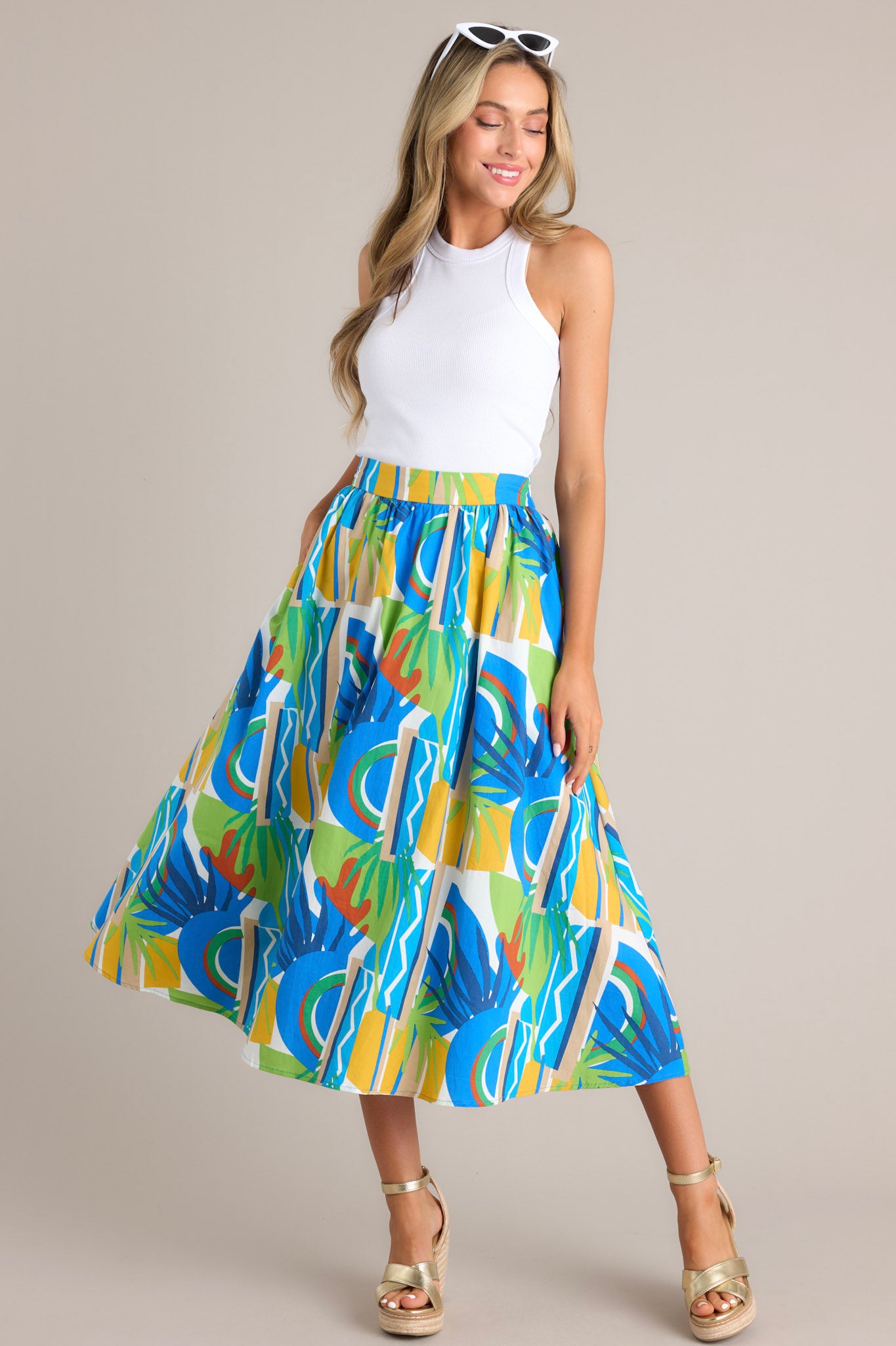 Full length view of a high-waisted A-line skirt with a vibrant abstract pattern in blue, green, and yellow.