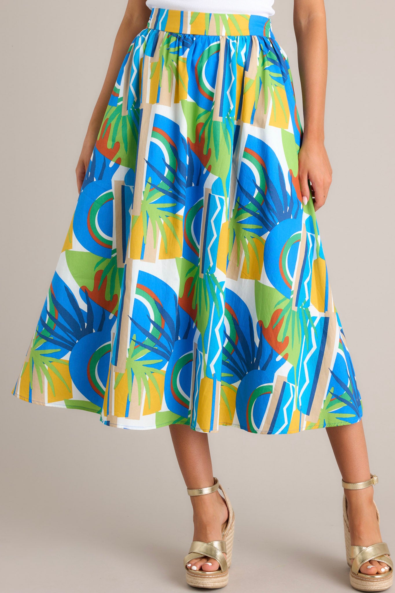 Close-up of the fabric and pattern of a high-waisted A-line skirt featuring an abstract design in blue, green, and yellow.
