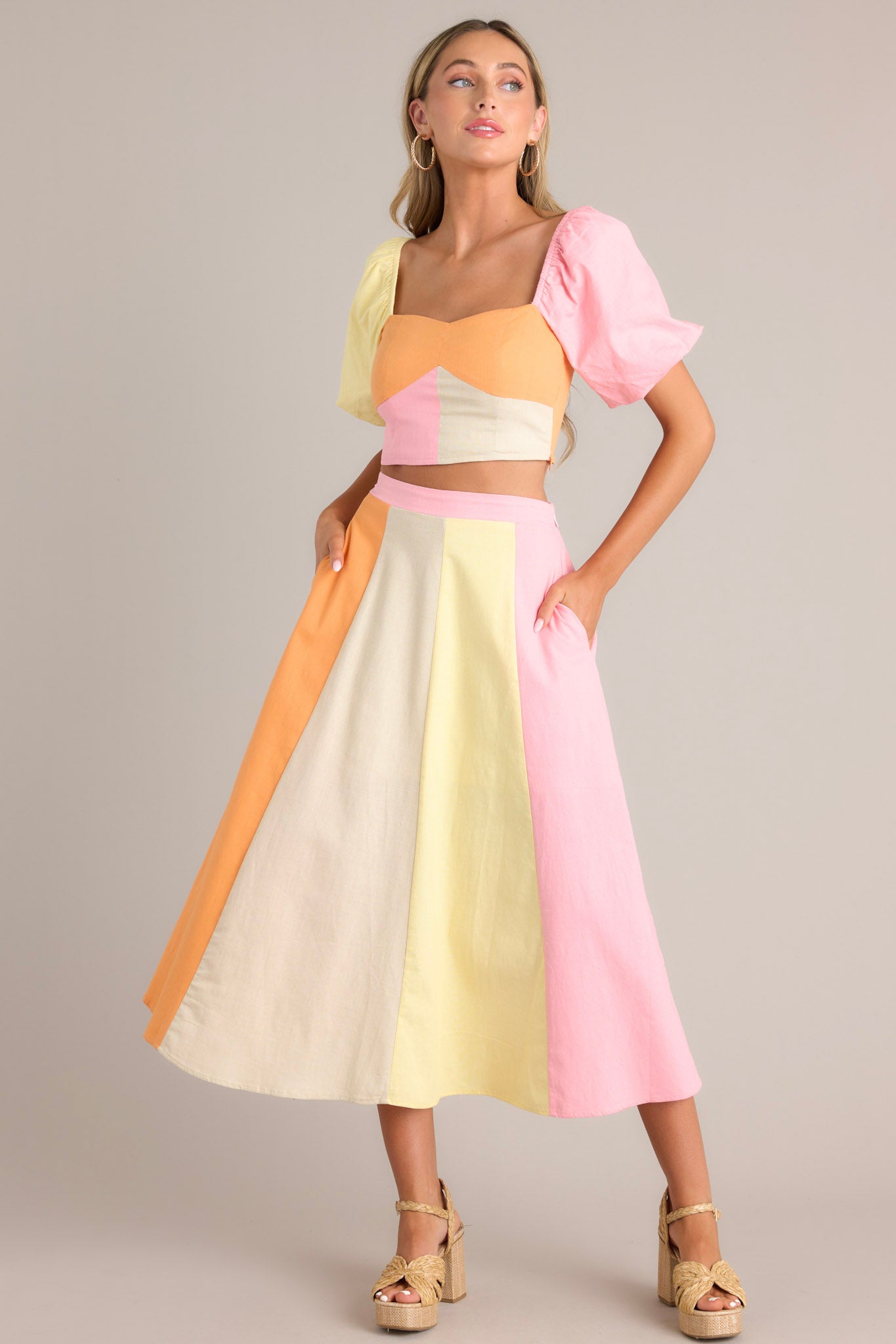 Angled full body view of this pastel crop top that features a sweetheart neckline, a self-tie back feature, a fully smocked back, a discrete side zipper, and elastic cuffed short puff sleeves.