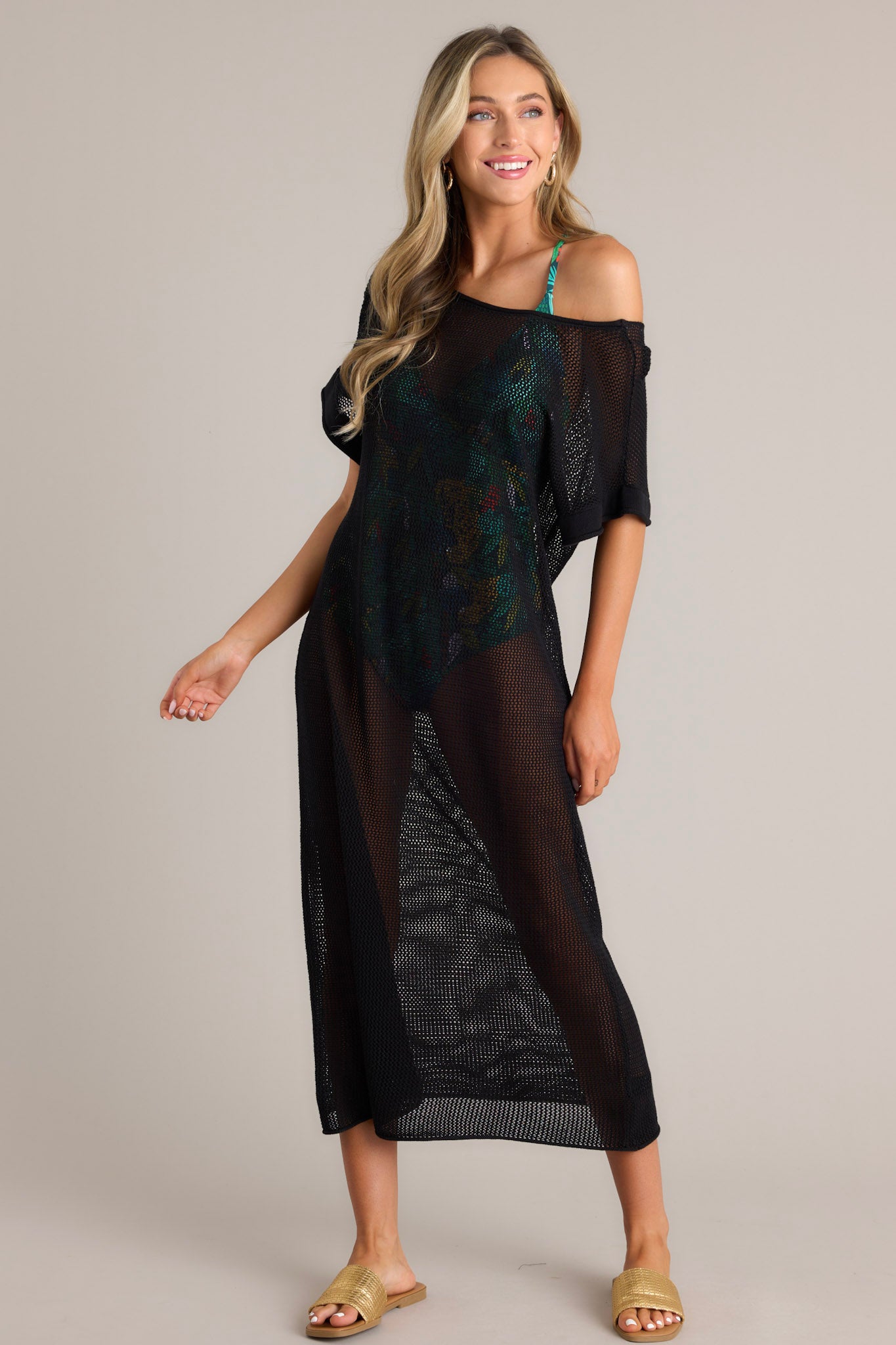 Front  view of this black cover-up dress that features a wide rounded neckline, open back feature, an open-knit design, and cuffed short sleeves.
