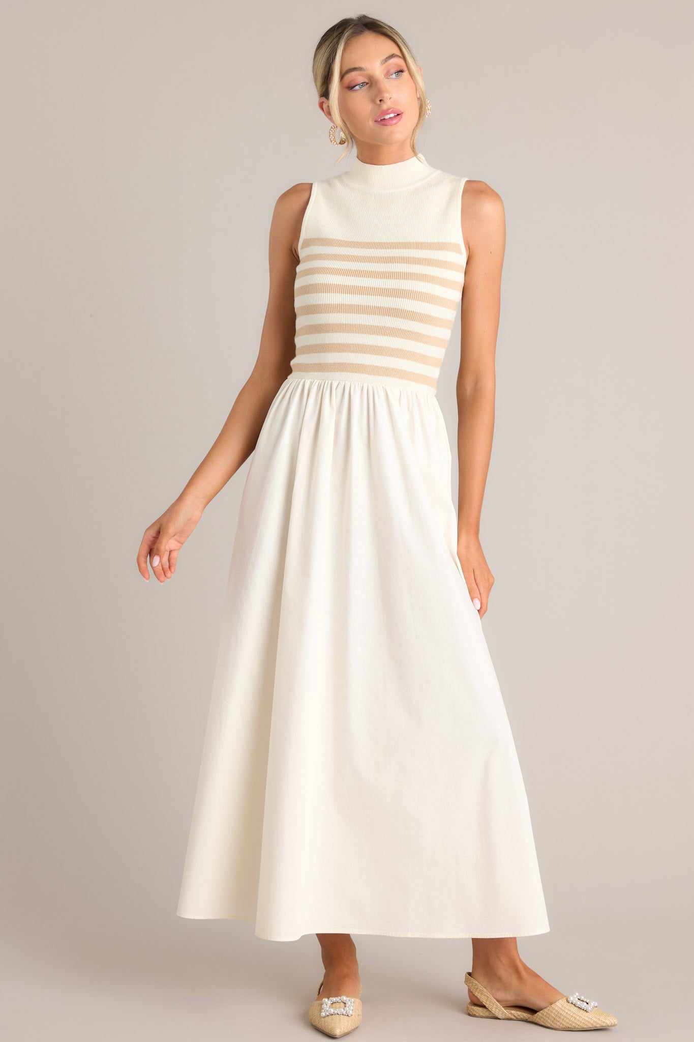 Front view of this dress that features a high neckline, a striped sweater bodice, and a flowy skirt.