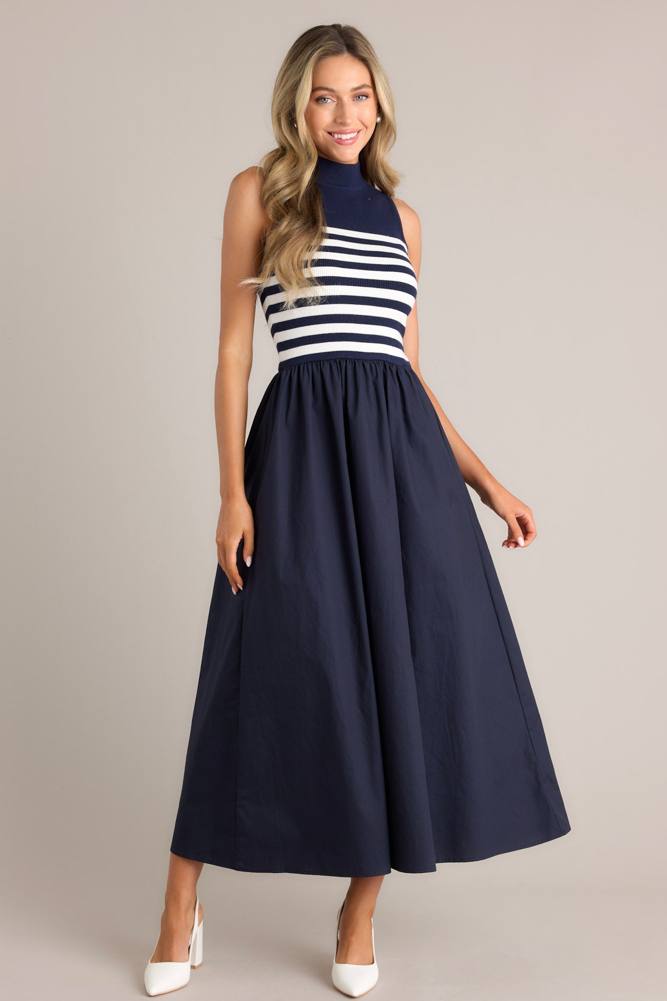 Midi dress with a navy sleeveless striped bodice and a flowing solid navy skirt.