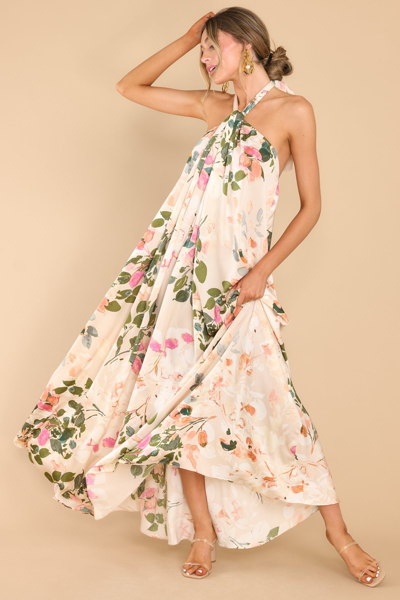 This tan floral dress features a high neckline with keyhole cutouts and halter self tie around the neck, open back, elastic along lower back seam, and a flowy fit throughout.