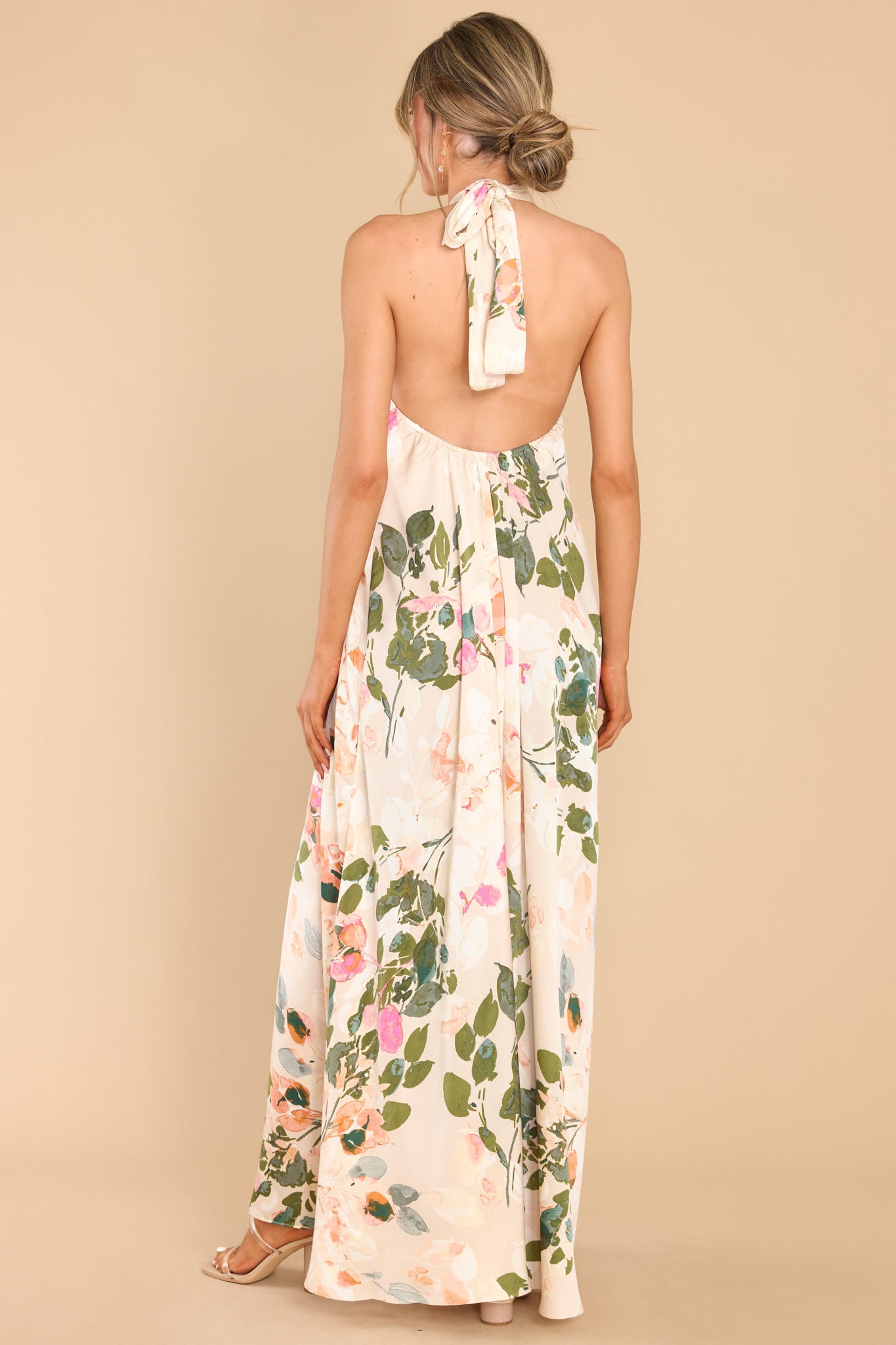 Back view of  this dress that features a high neckline with keyhole cutouts and halter self tie around the neck, open back, elastic along lower back seam, and a flowy fit throughout.