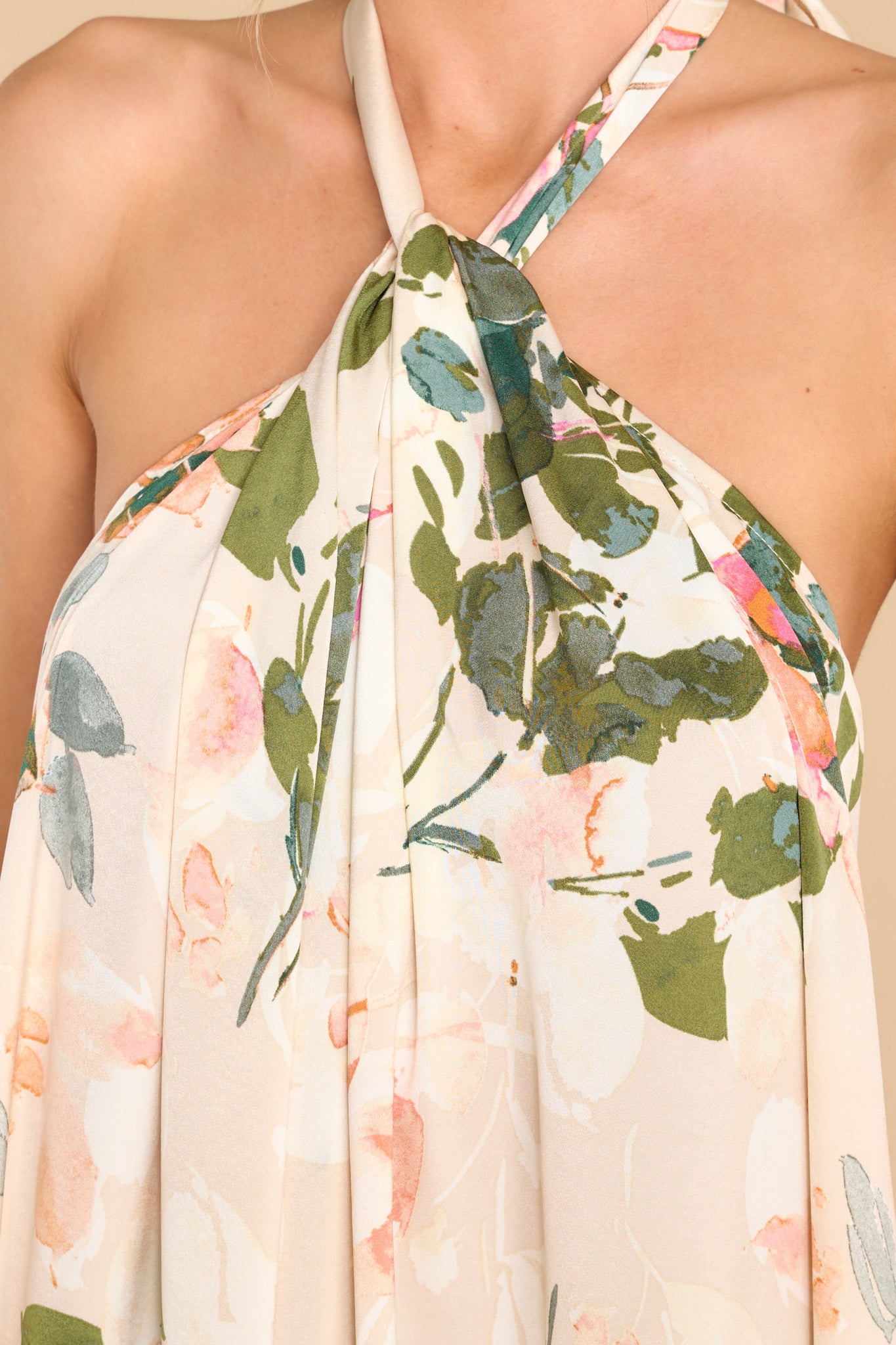 Close up view of this dress that features a high neckline with keyhole cutouts and halter self tie around the neck, open back, elastic along lower back seam, and a flowy fit throughout.