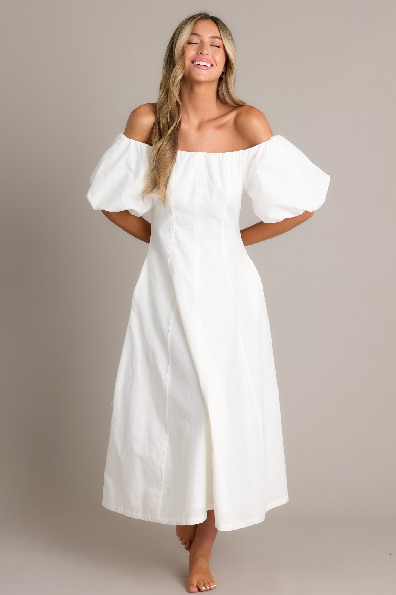 Elegant off-the-shoulder white dress with voluminous puffed sleeves, a fitted bodice, and a flowing ankle-length skirt, perfect for a chic and sophisticated look.