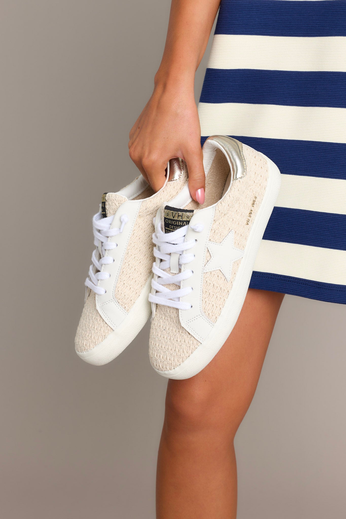 Side view of these natural sneakers that feature a rounded toe, no-tie laces, replacement laces, star detailing, and a thick sole.