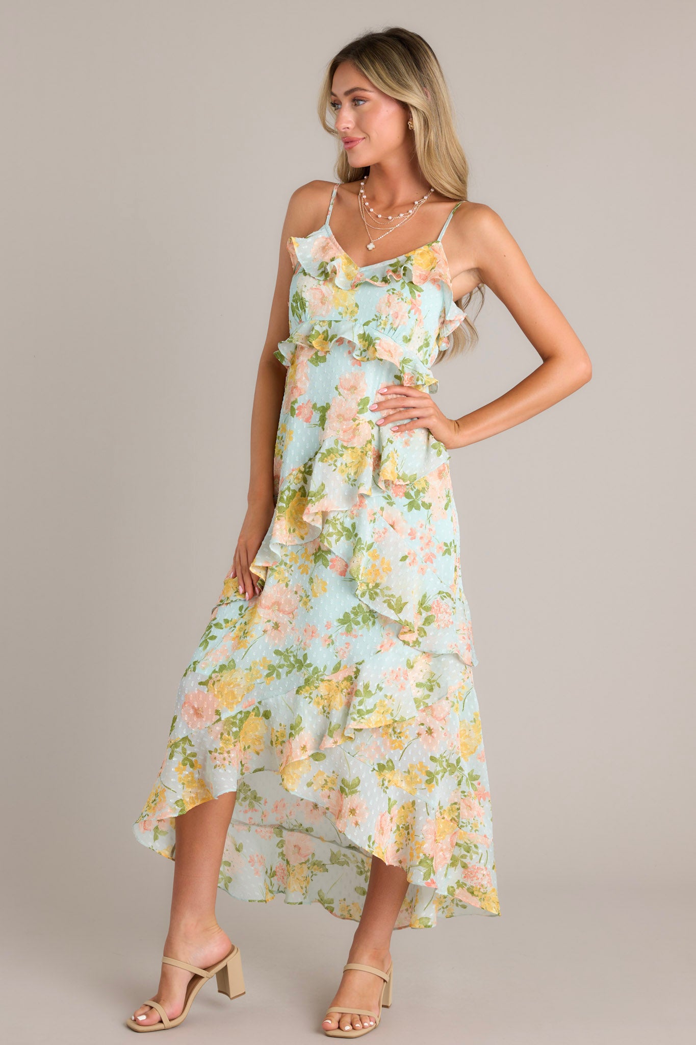 This blue floral dress features asymmetrical ruffles cascading down the dress.