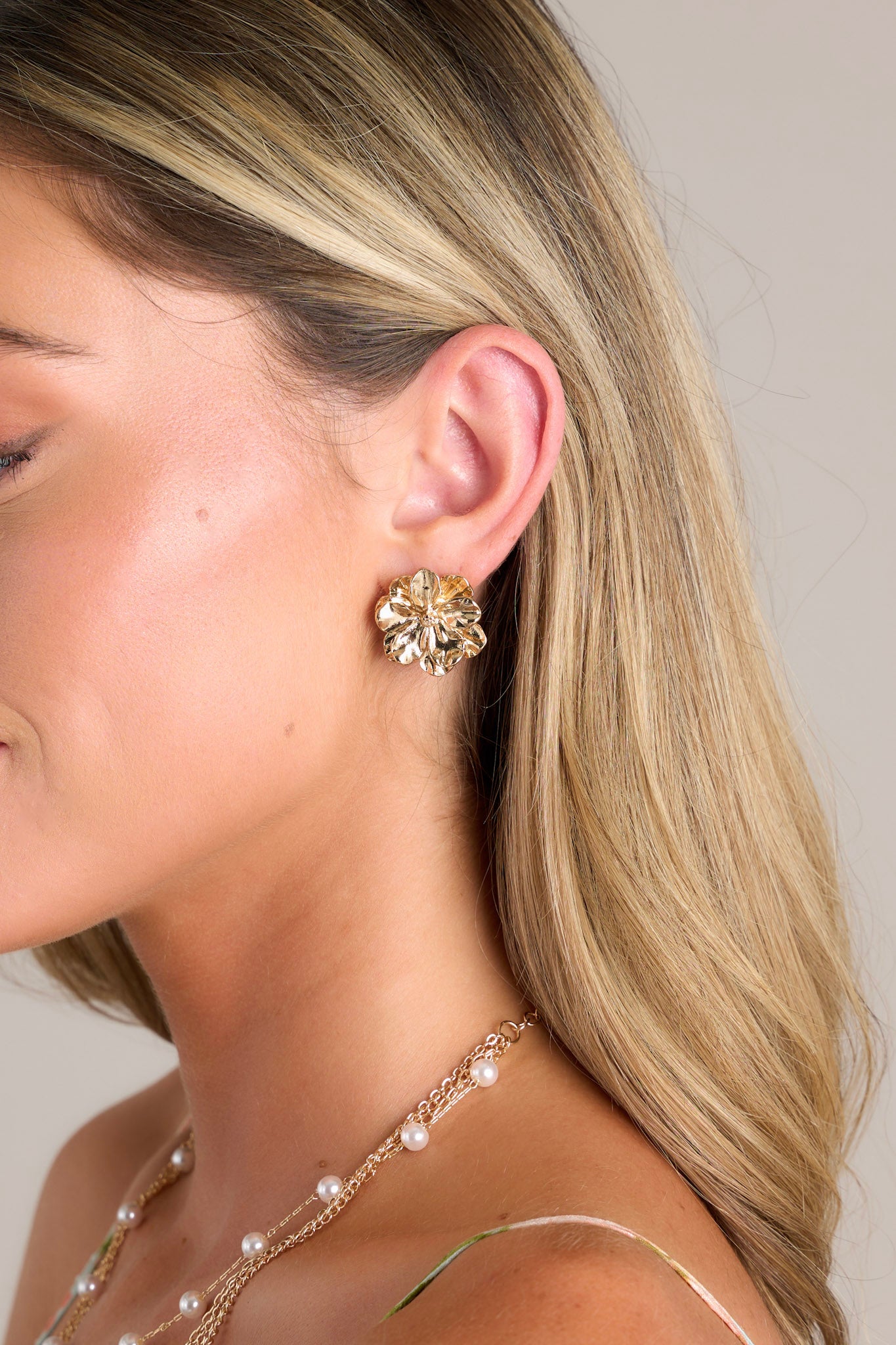 These earrings feature a gold finish, textured multi petal design, and secure post backing.