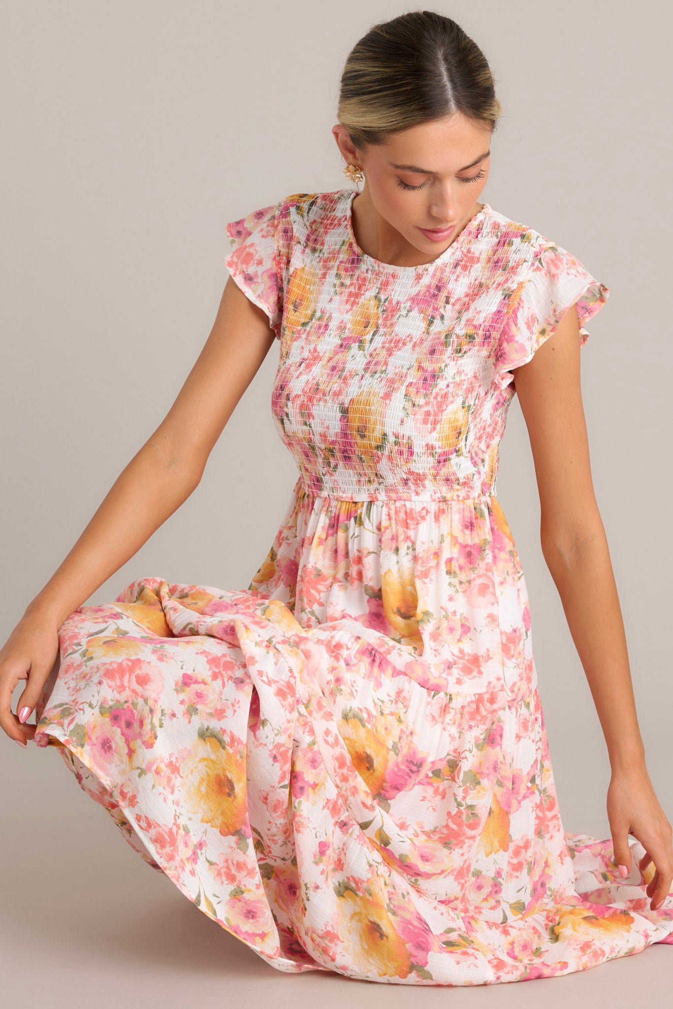 Close-up of this pink floral midi dress showing the high neckline, smocked bodice, and flutter sleeves with the colorful floral pattern.