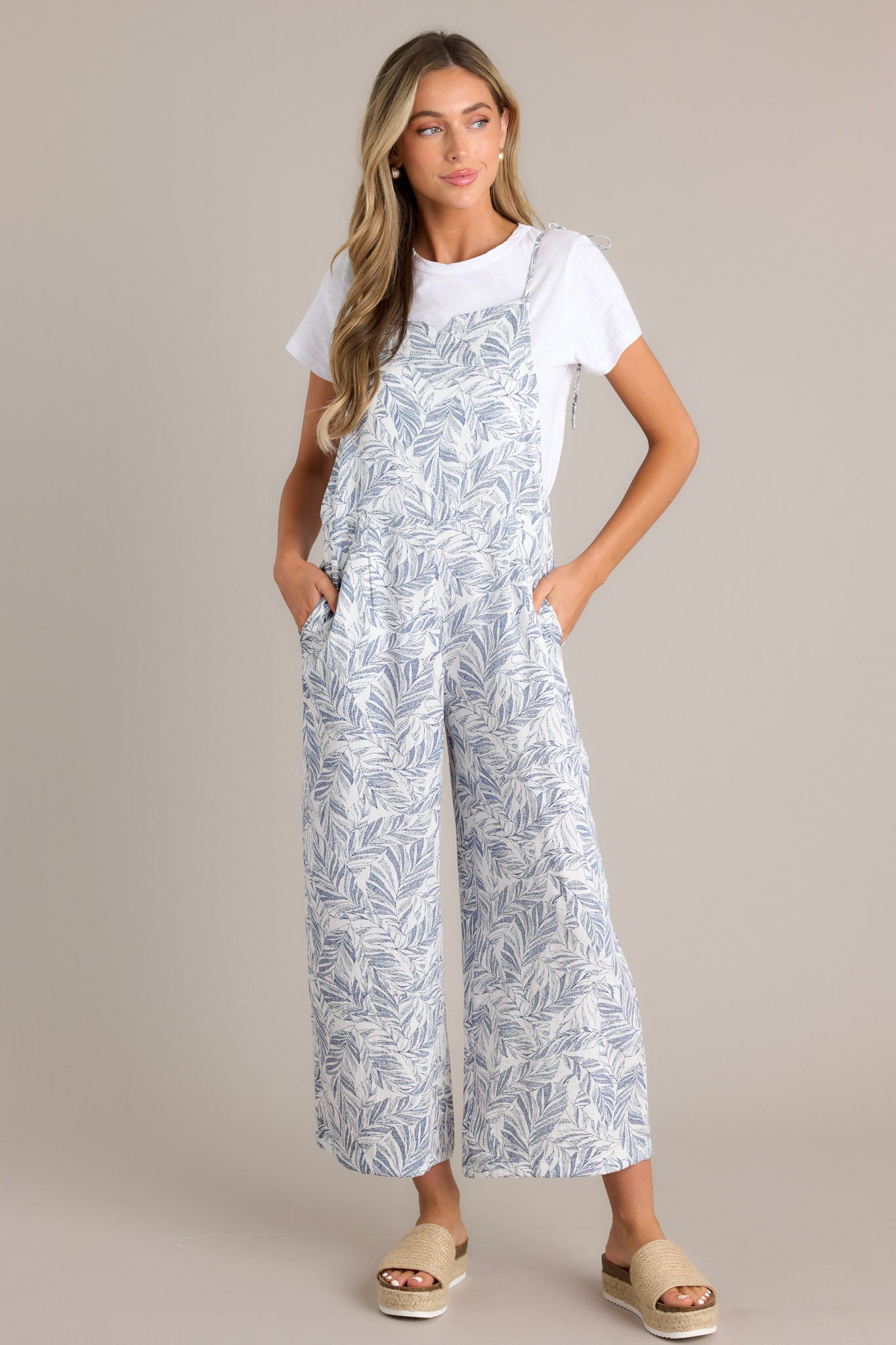 Full body view of this Relaxed-fit jumpsuit with a blue and white leaf pattern, wide leg cut, and adjustable shoulder ties.