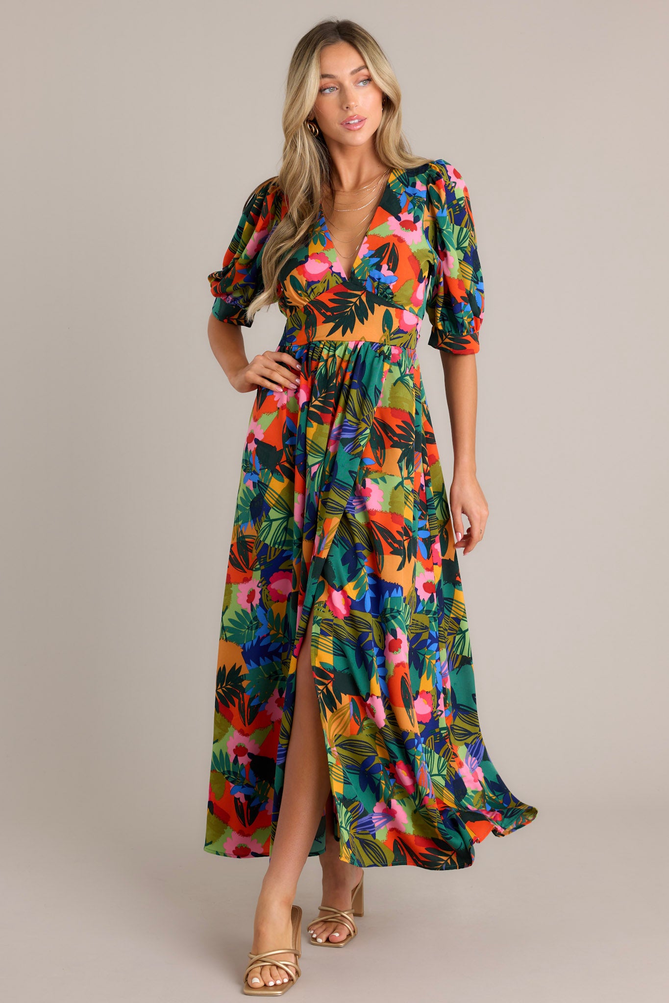 This green multi maxi dress features a plunging v-neckline, a keyhole with button closure in the back, a thick waistband, a smocked back insert with a self-tie feature, button cuffed half sleeves, and a faux wrap design.