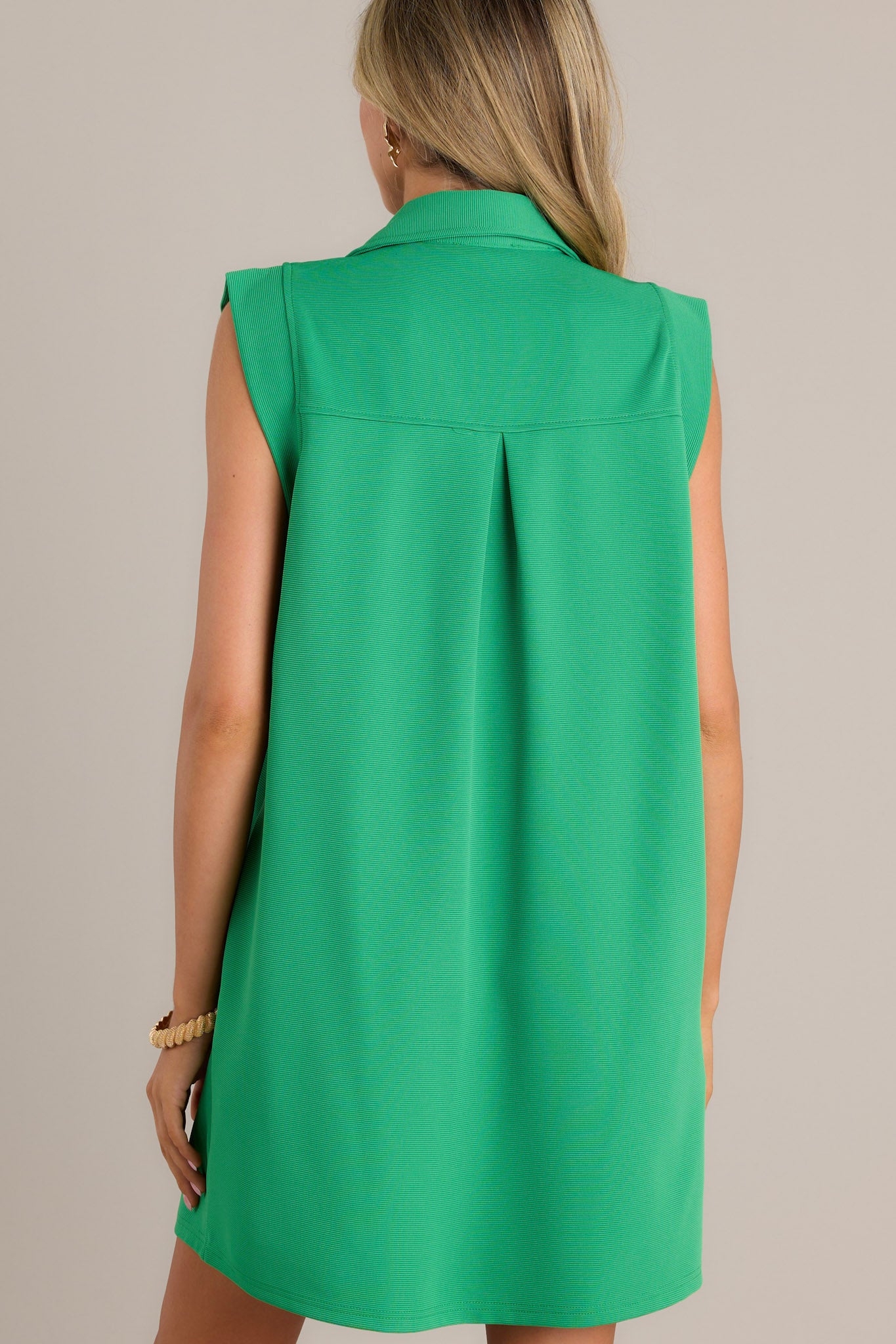 Back view of a sleeveless green shift dress with a simple, clean design, highlighting the collared neckline.