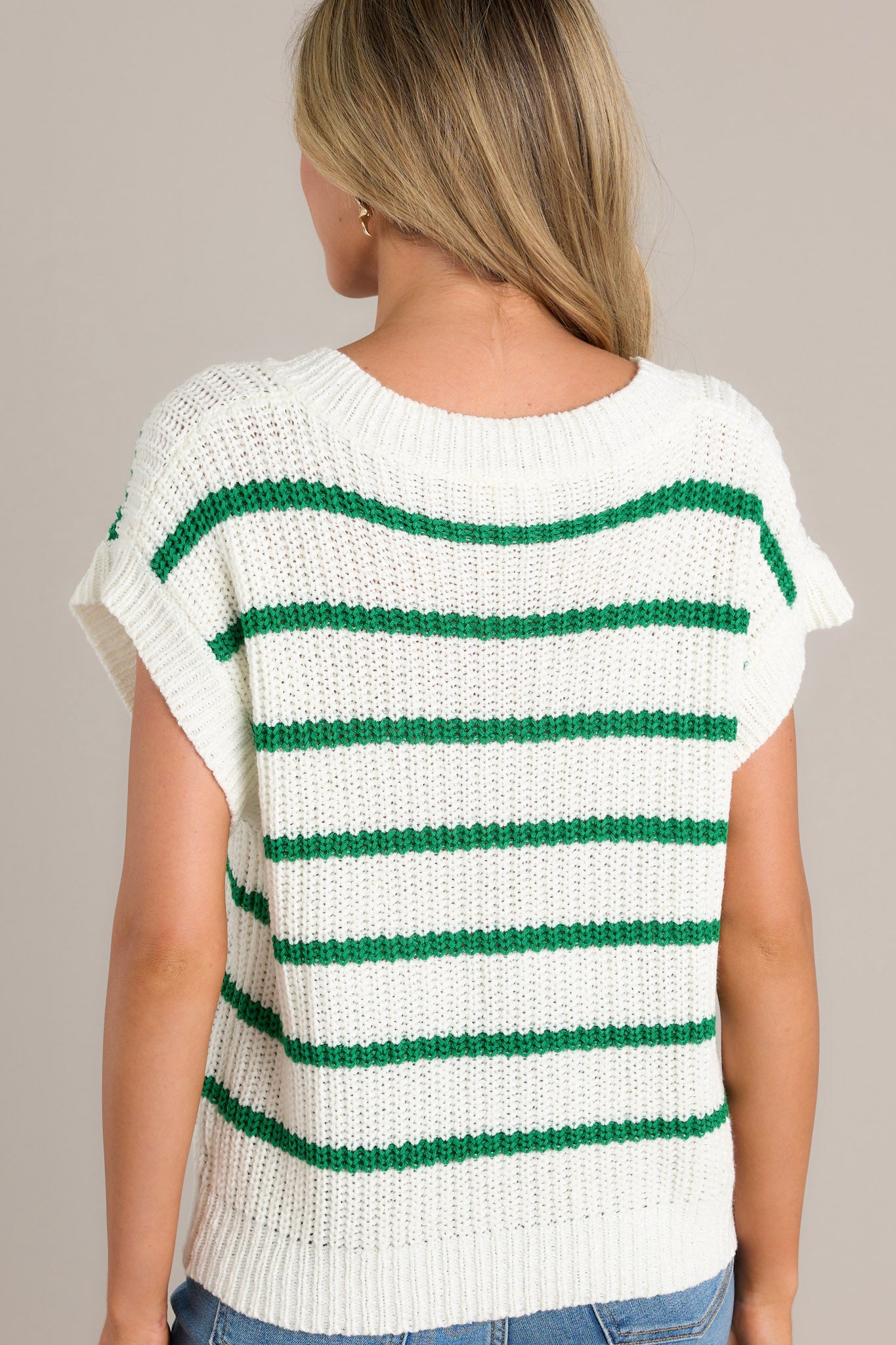 Back view of this green stripe sweater top that features a ribbed v-neckline, a soft chunky knit material, horizontal stripes, a ribbed hemline, and ribbed short sleeves.