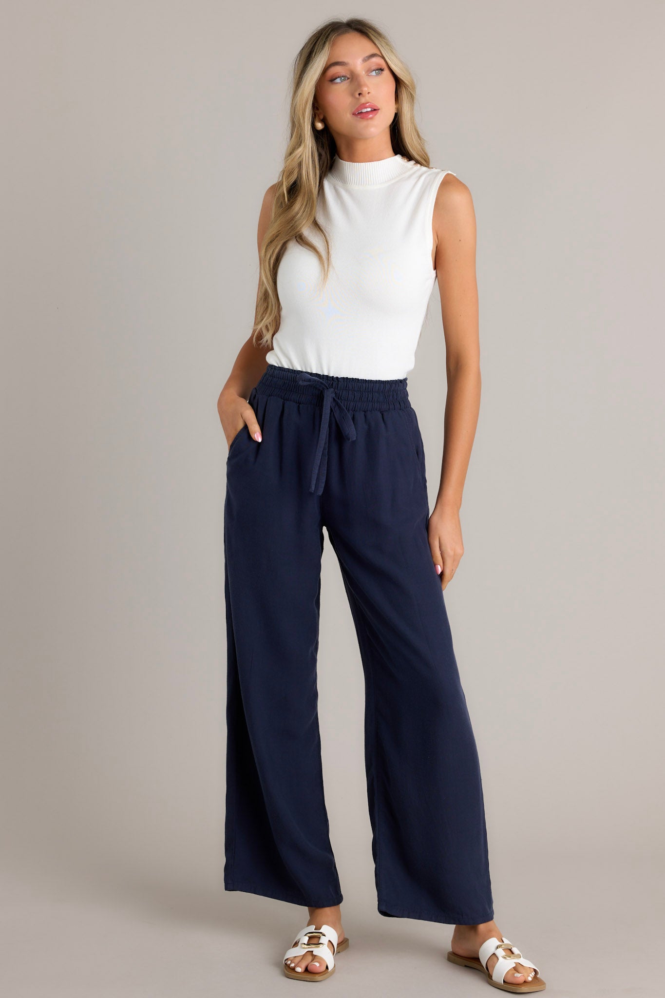 Navy wide-leg pants with an elastic waistband and drawstring, paired with white sandals.