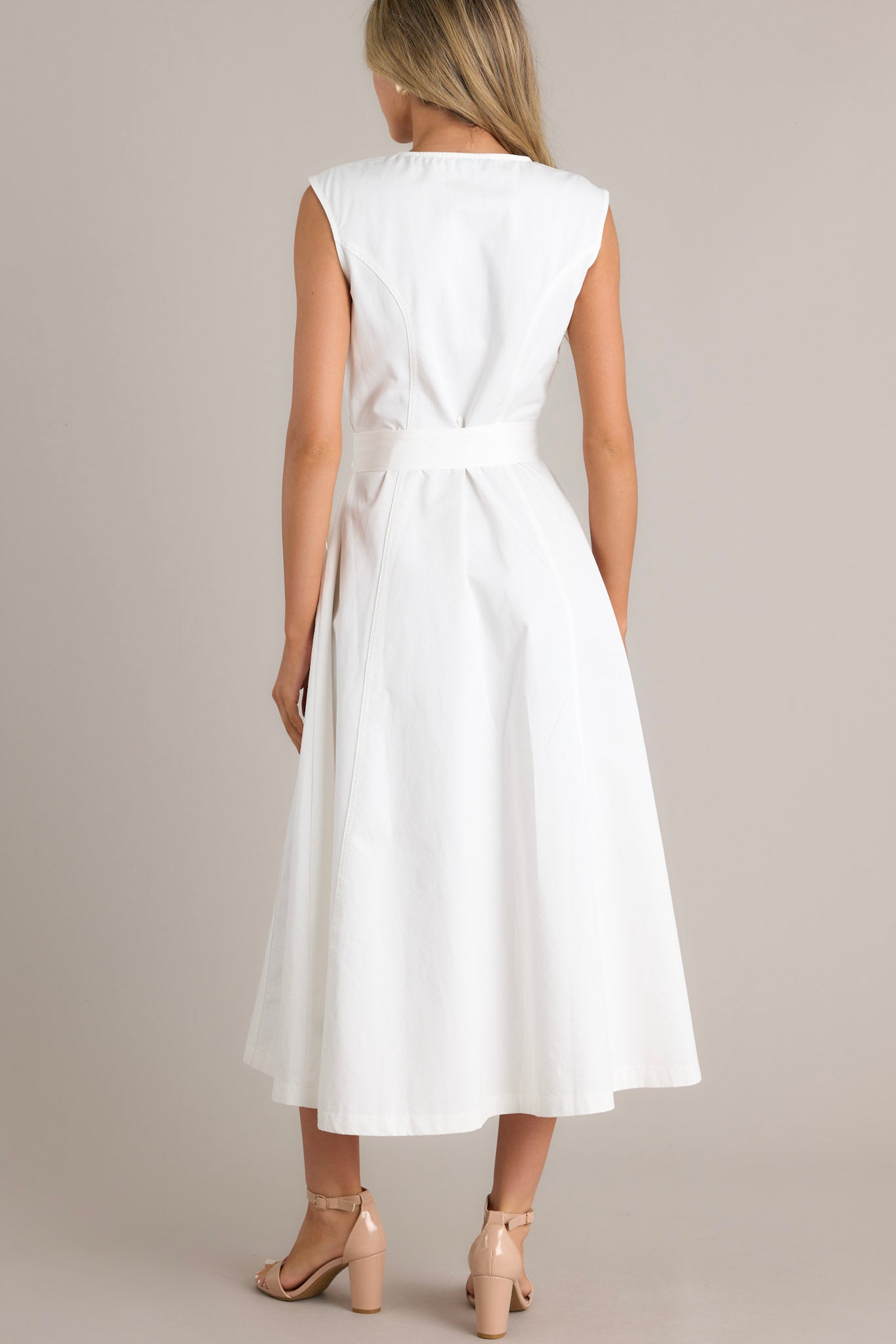 White sleeveless midi dress with a front zipper, fitted bodice, wide waist tie, and flared skirt.
