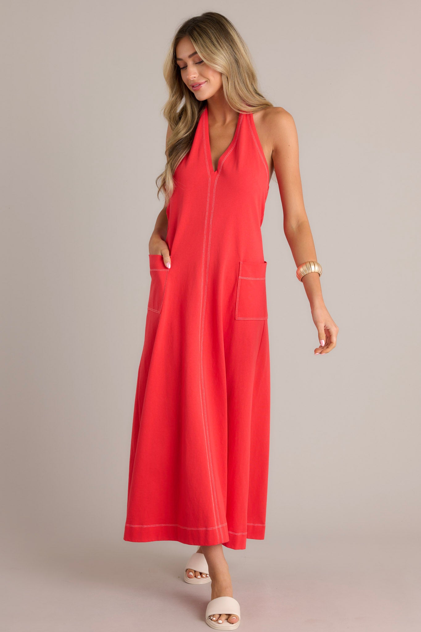 Full body view of this Halter-style red maxi dress featuring a deep V-neck and two front pockets.